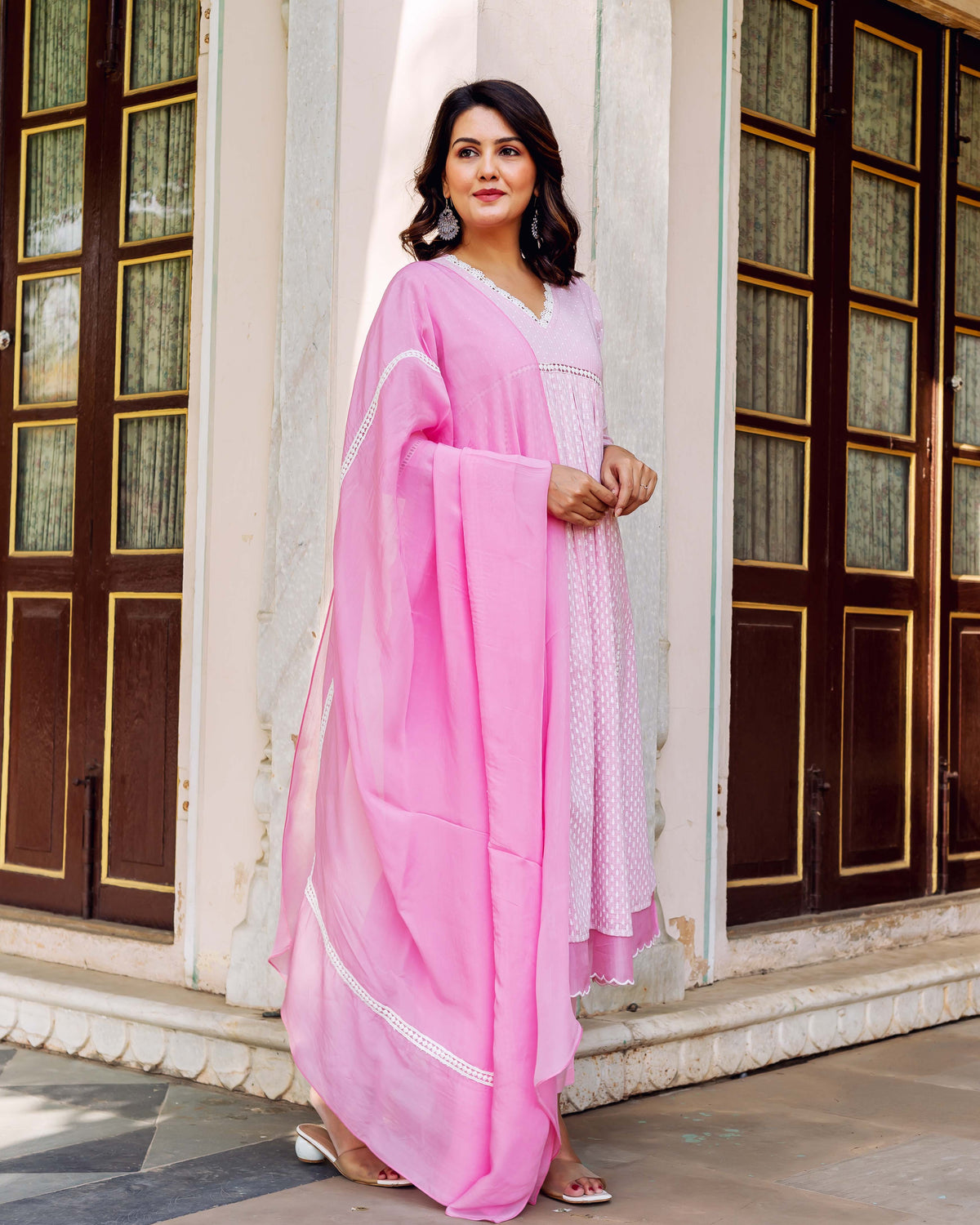 A woman in a pink and white hand-block-printed kurta with a matching dupatta.