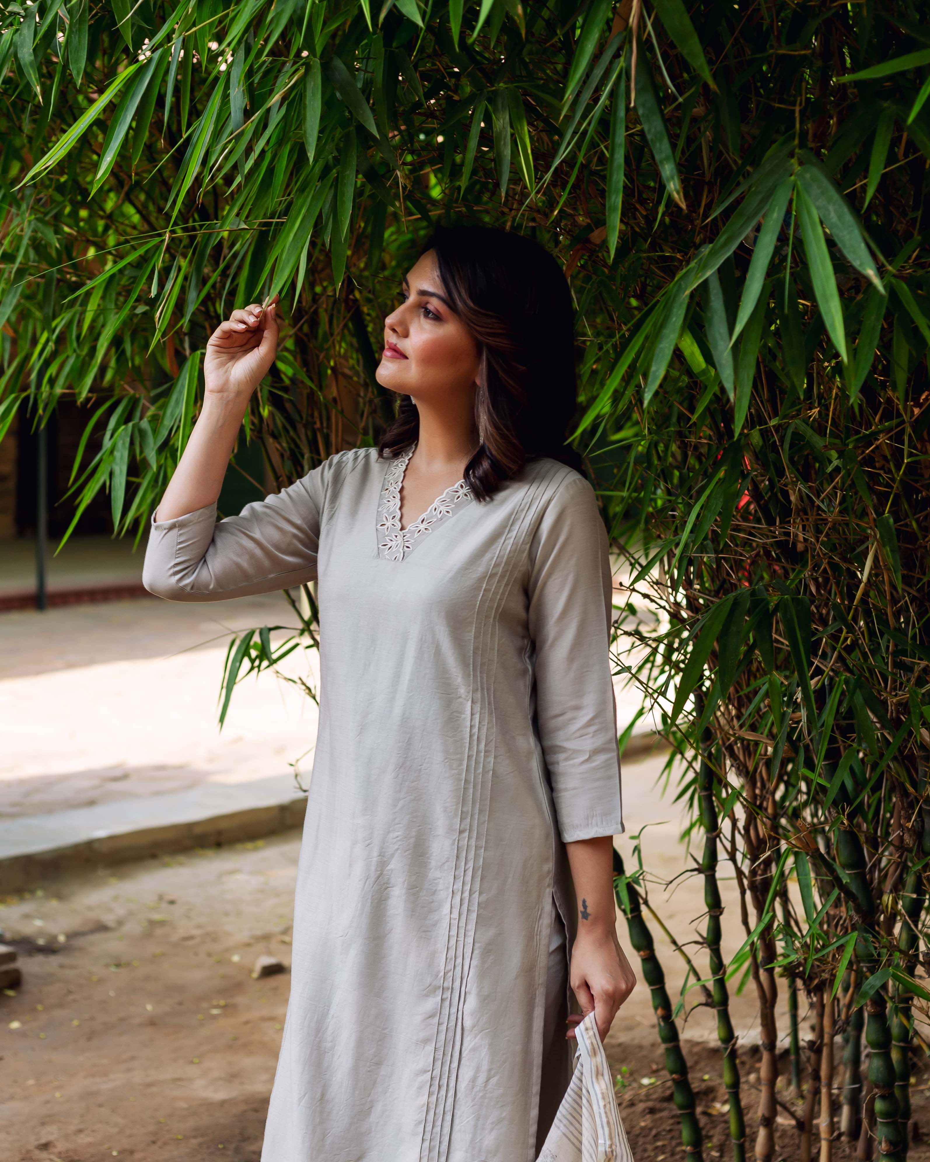 Model wears a silver mist Chanderi silk kurta with embroidered V-neck and vertical pleats.
