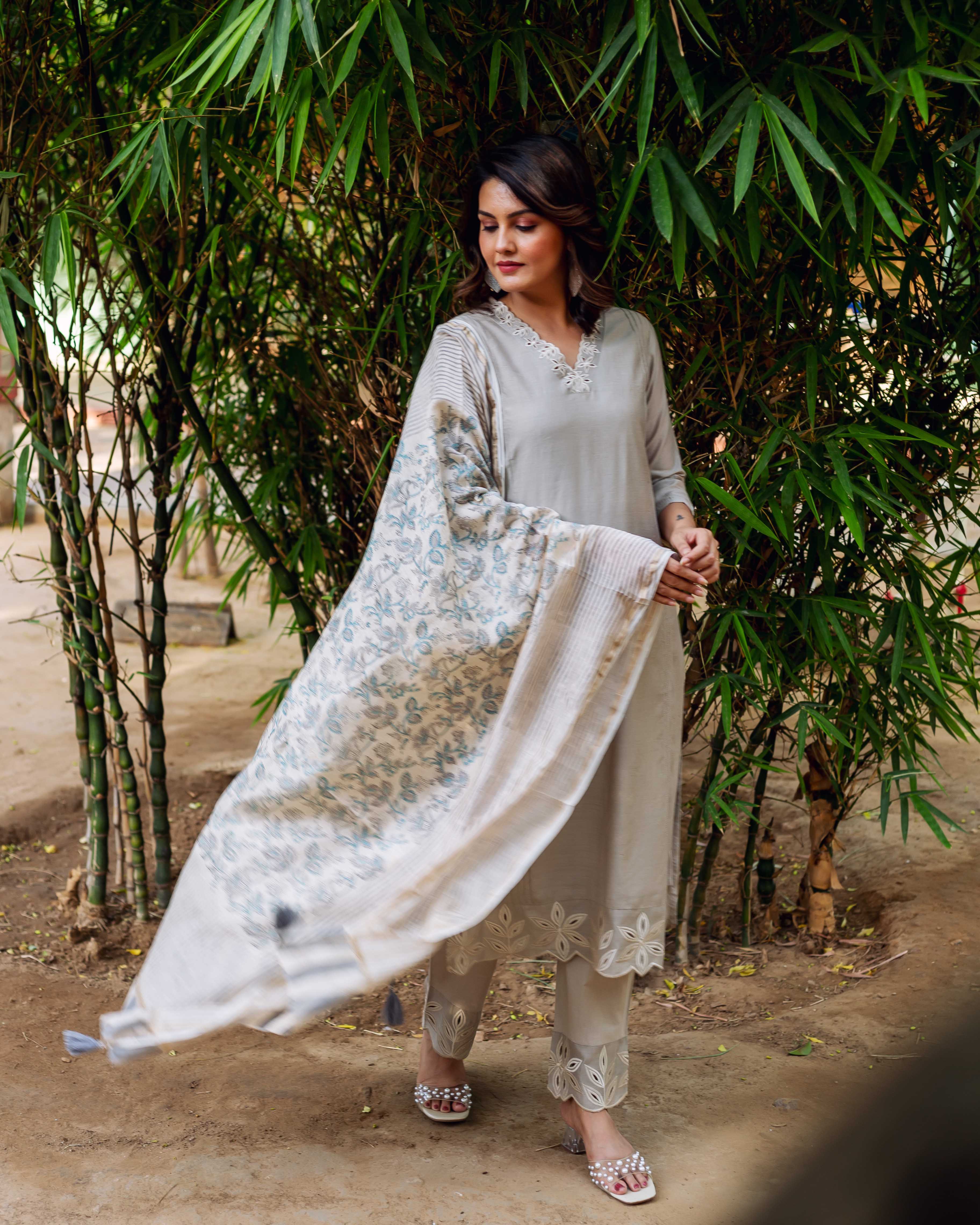 Woman models a pale grey embroidered kurta, cut-out pants, and floral block-printed off-white dupatta.