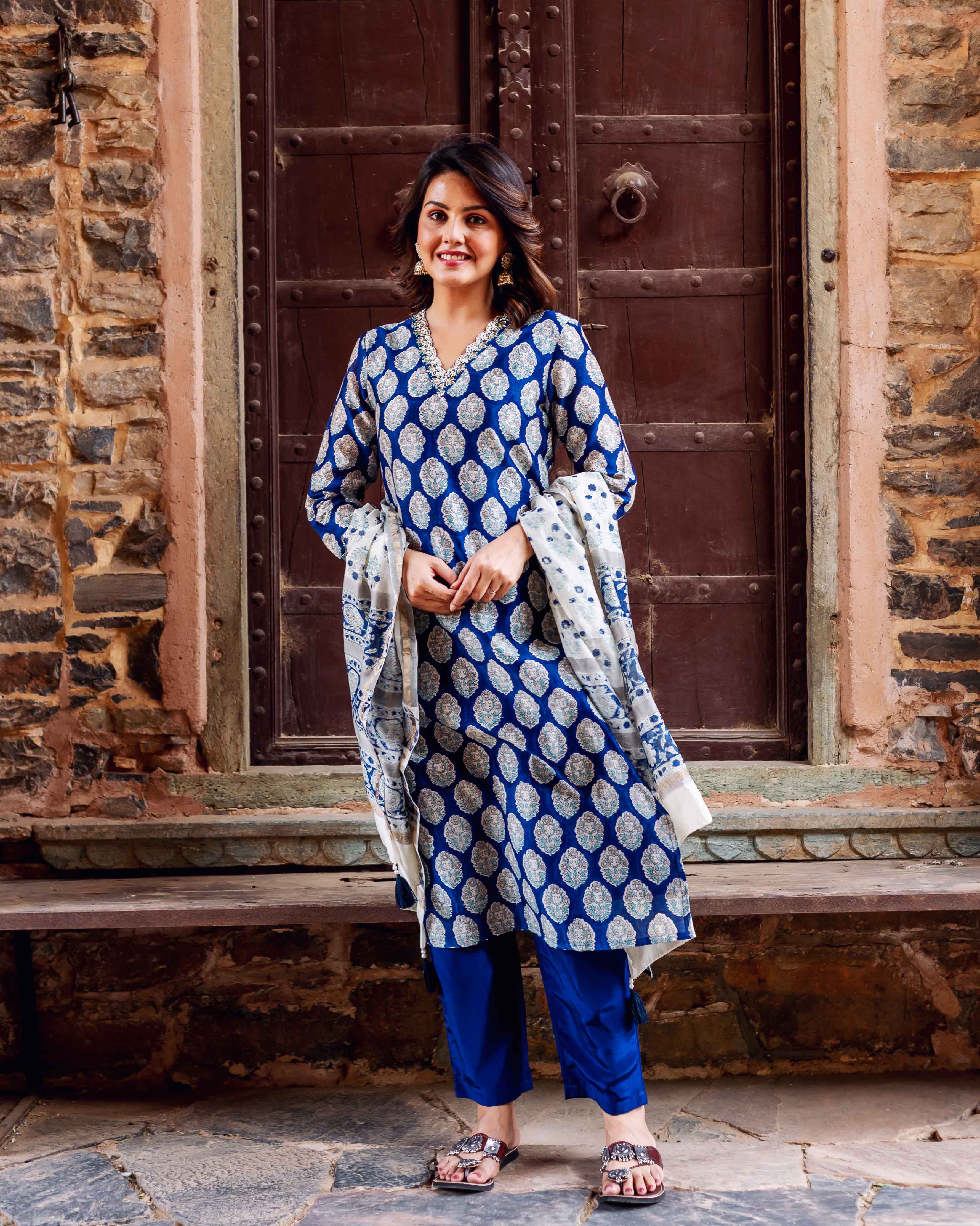 Smiling woman in indigo blue booti block print kurta set with matching dupatta.