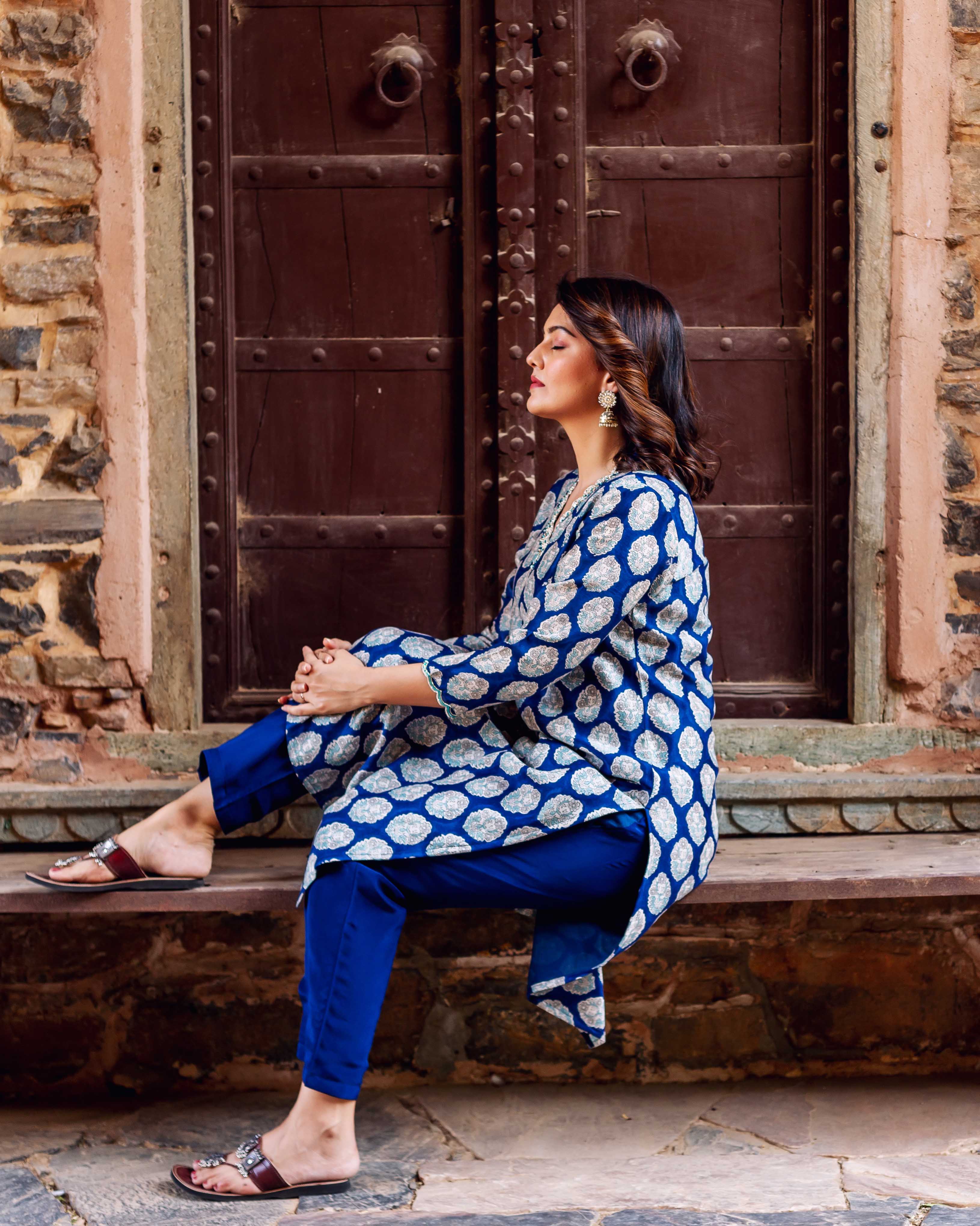 Side angle of woman in indigo blue booti print kurta and matching pants.