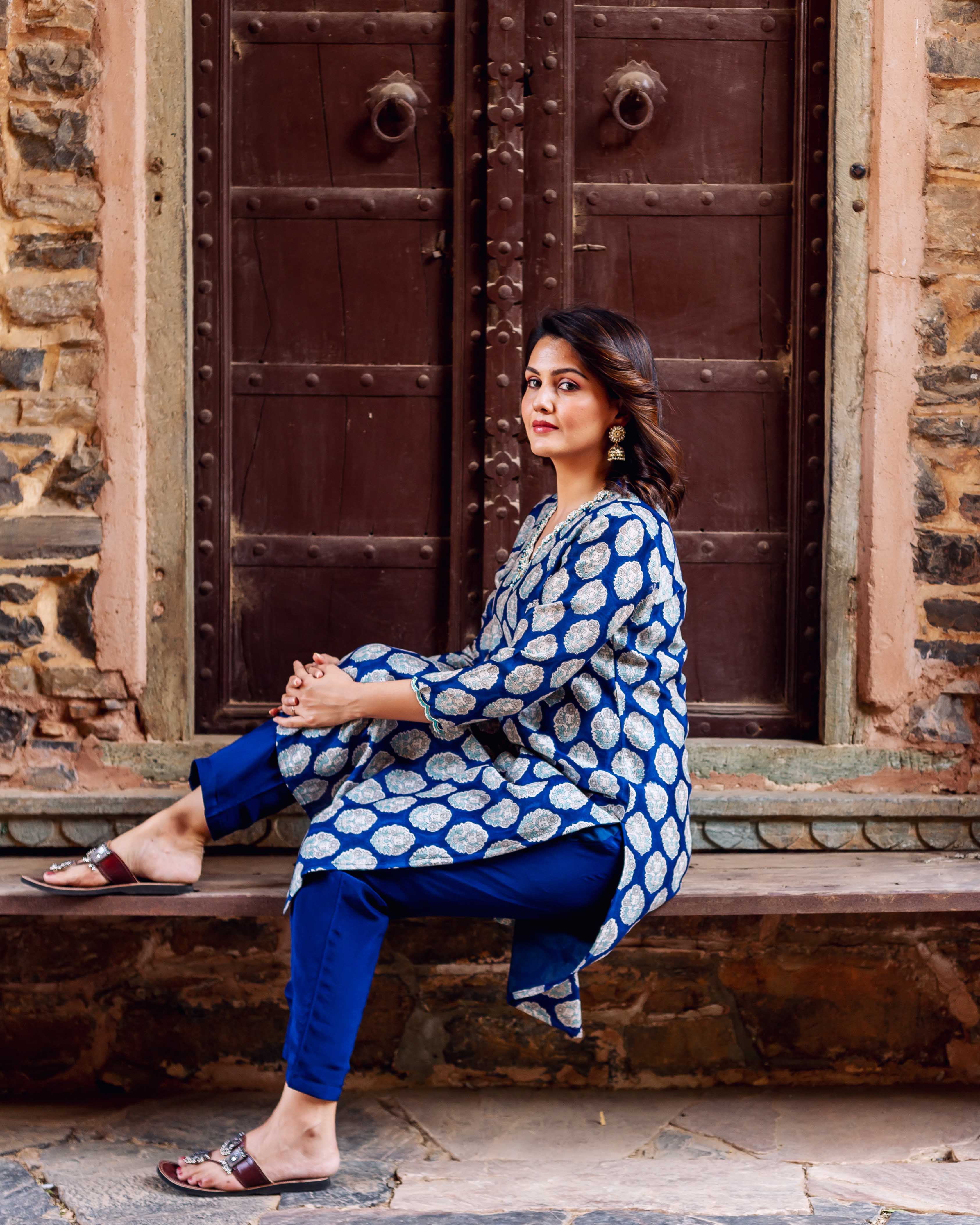 Model seated in full-look indigo blue booti print Chanderi silk kurta with royal blue pants.