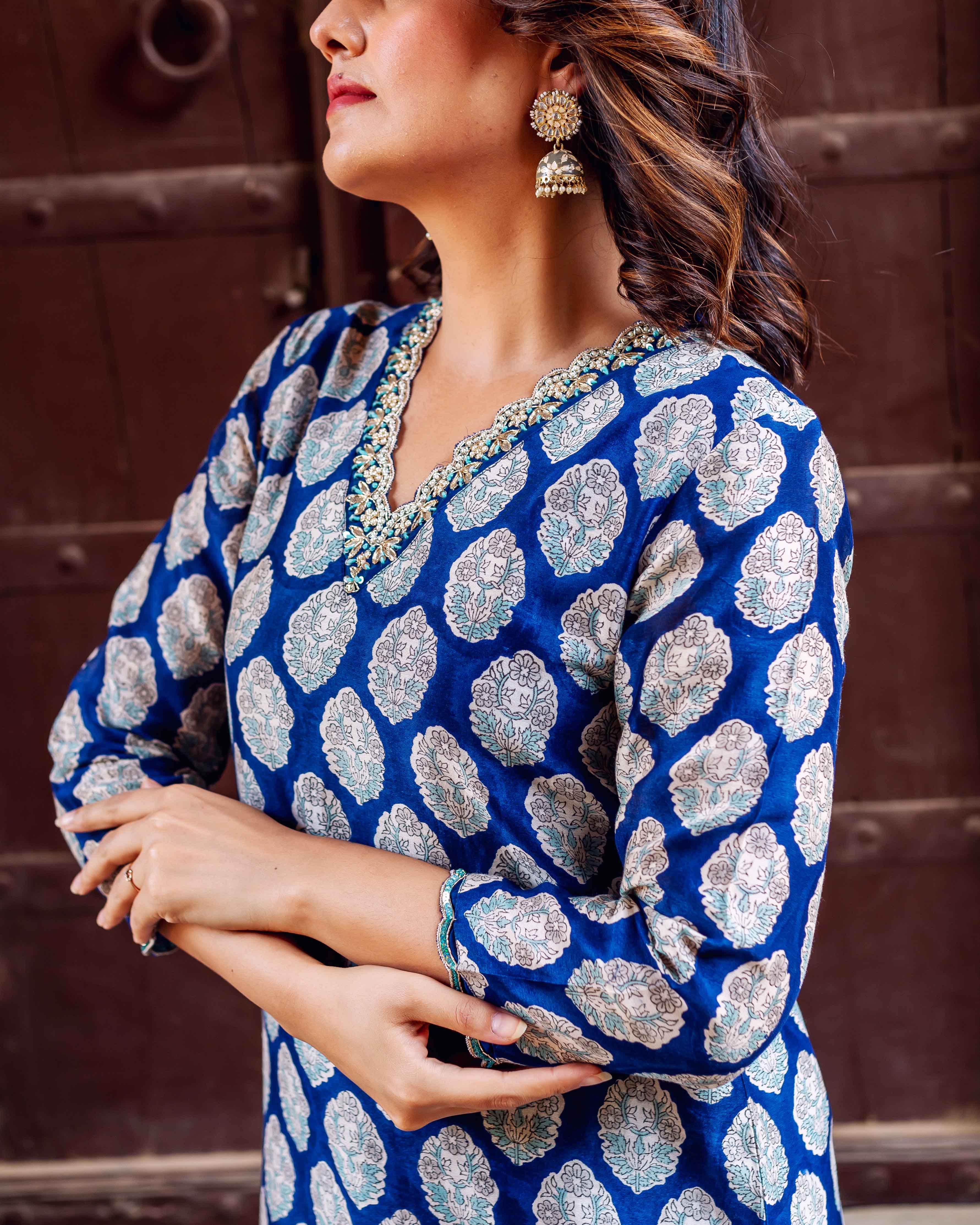Side view of model in indigo blue hand-block-printed booti kurta with embellished neckline.