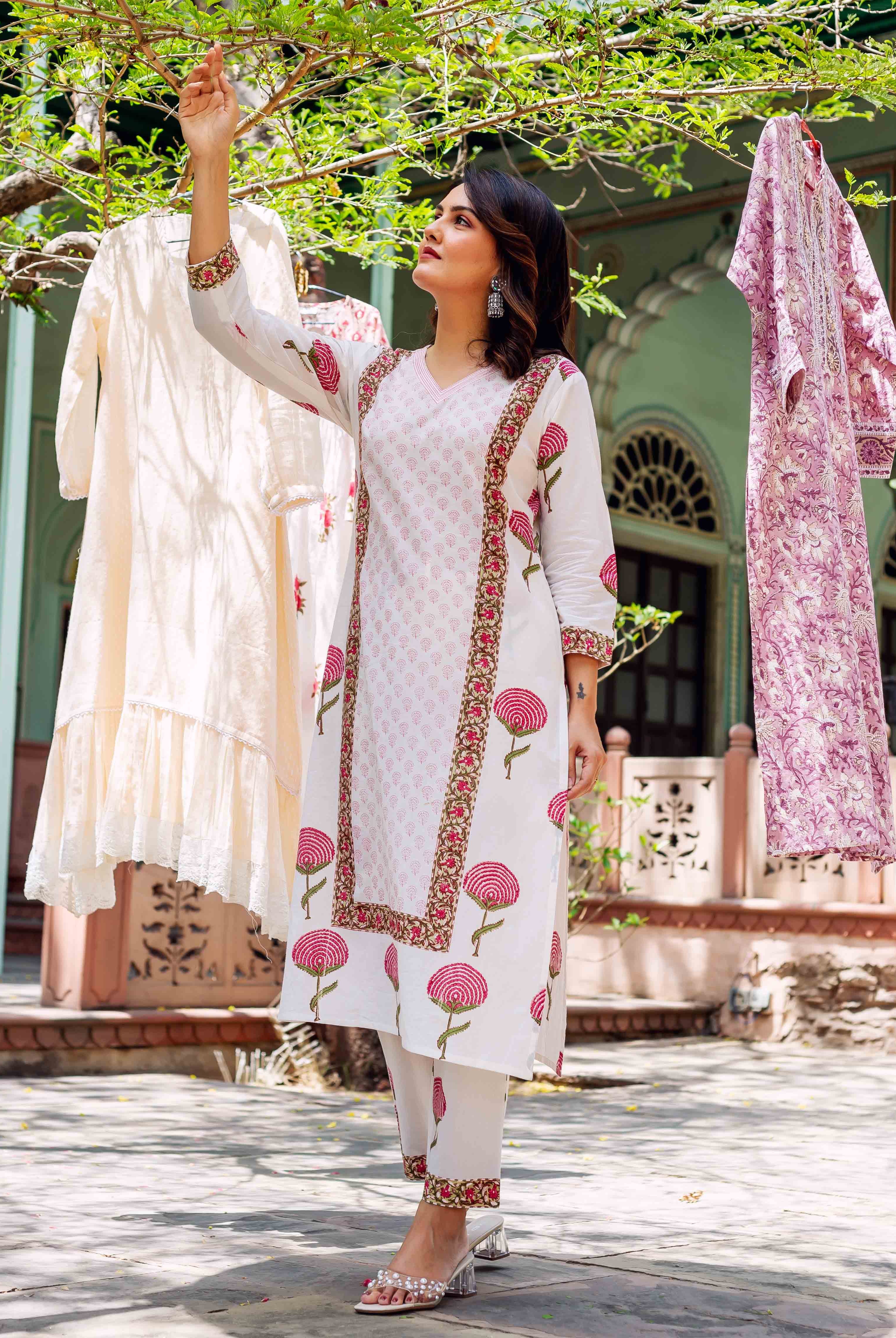 Model wearing white hand-block printed cotton kurta set featuring pink floral motifs.
