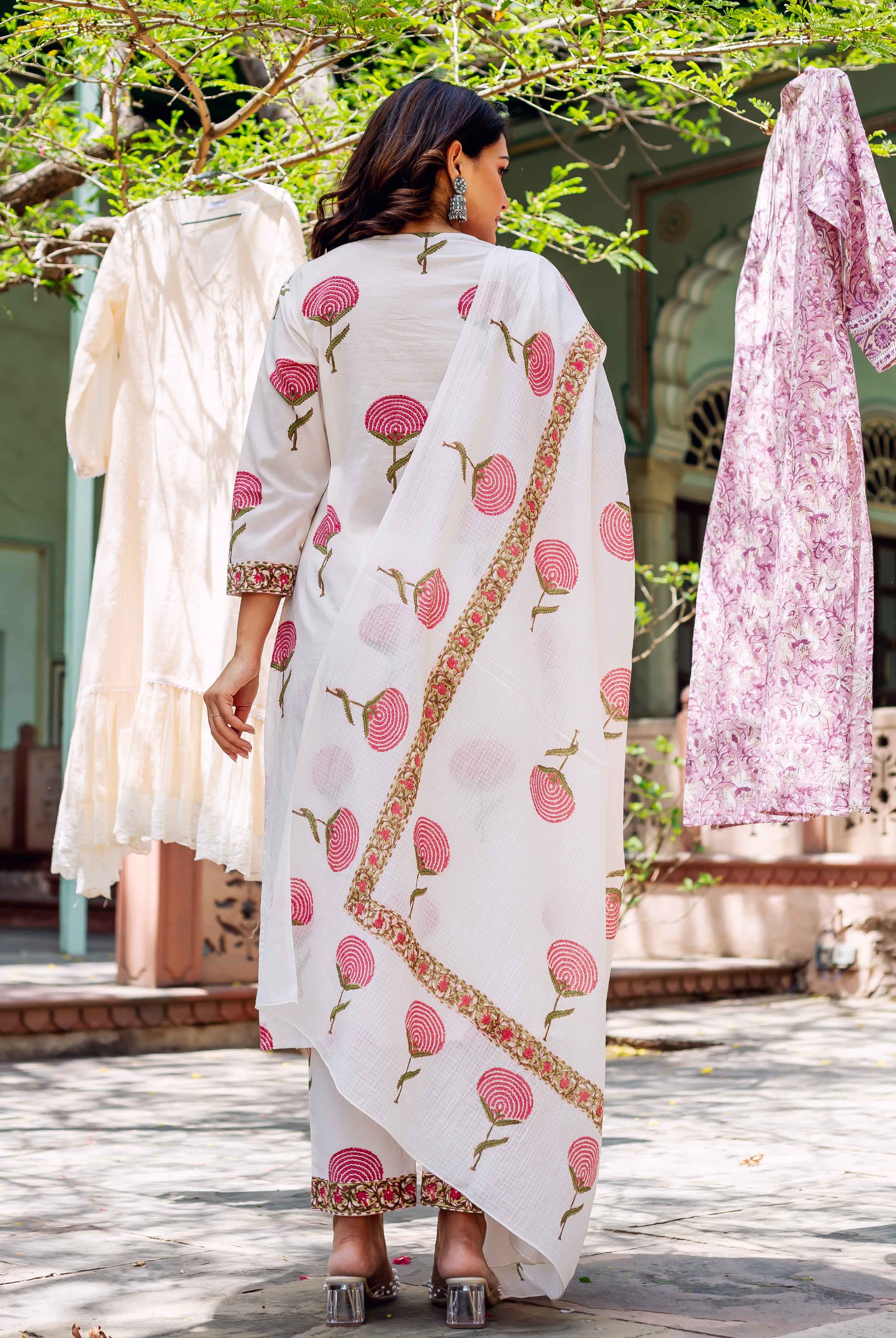 Back view of model in white cotton kurta set with pink hand-block printed flowers.
