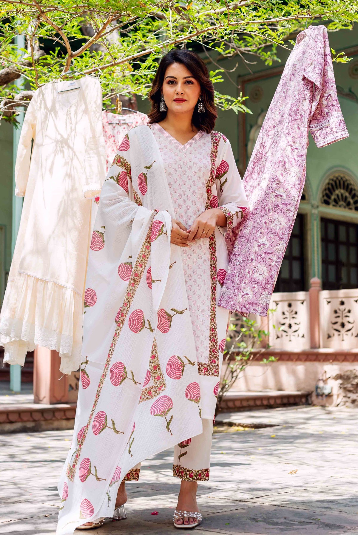 Full-length model wears a white hand-block-printed cotton kurta set with pink floral patterns.