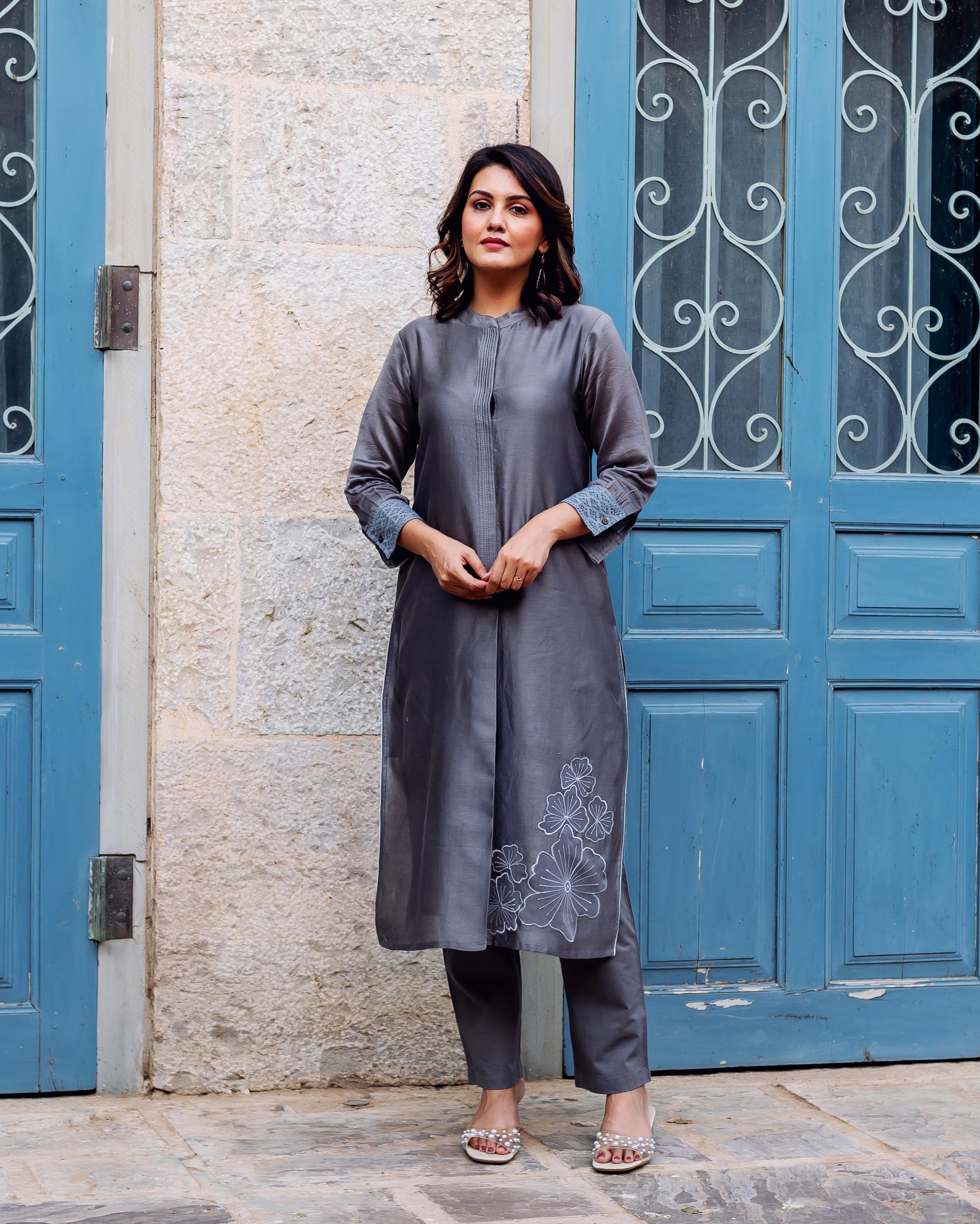 Woman wearing a silver mist chanderi silk kurta with white floral embroidery.