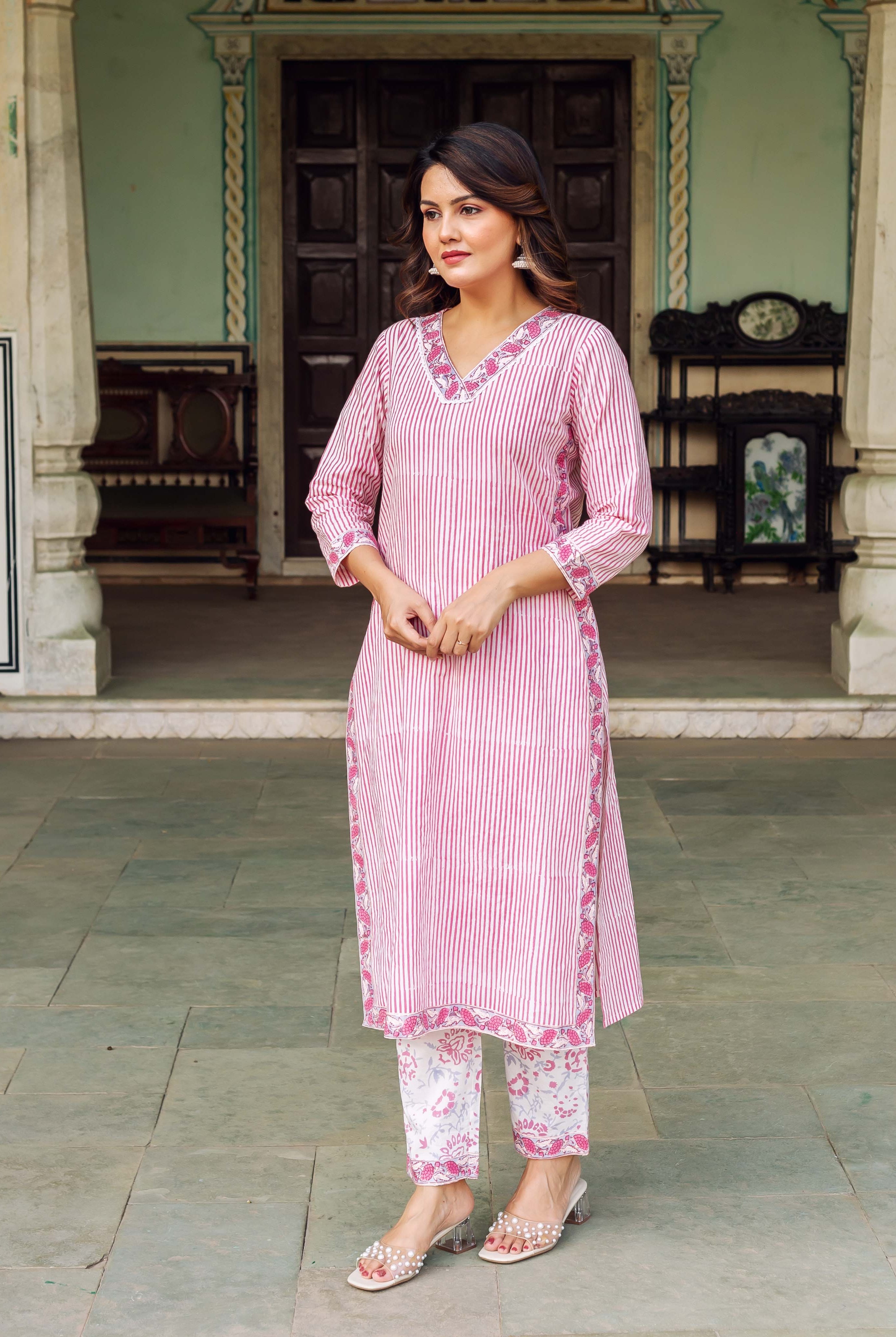 Full shot of woman in pink and white striped kurta set with floral block-print pants.
