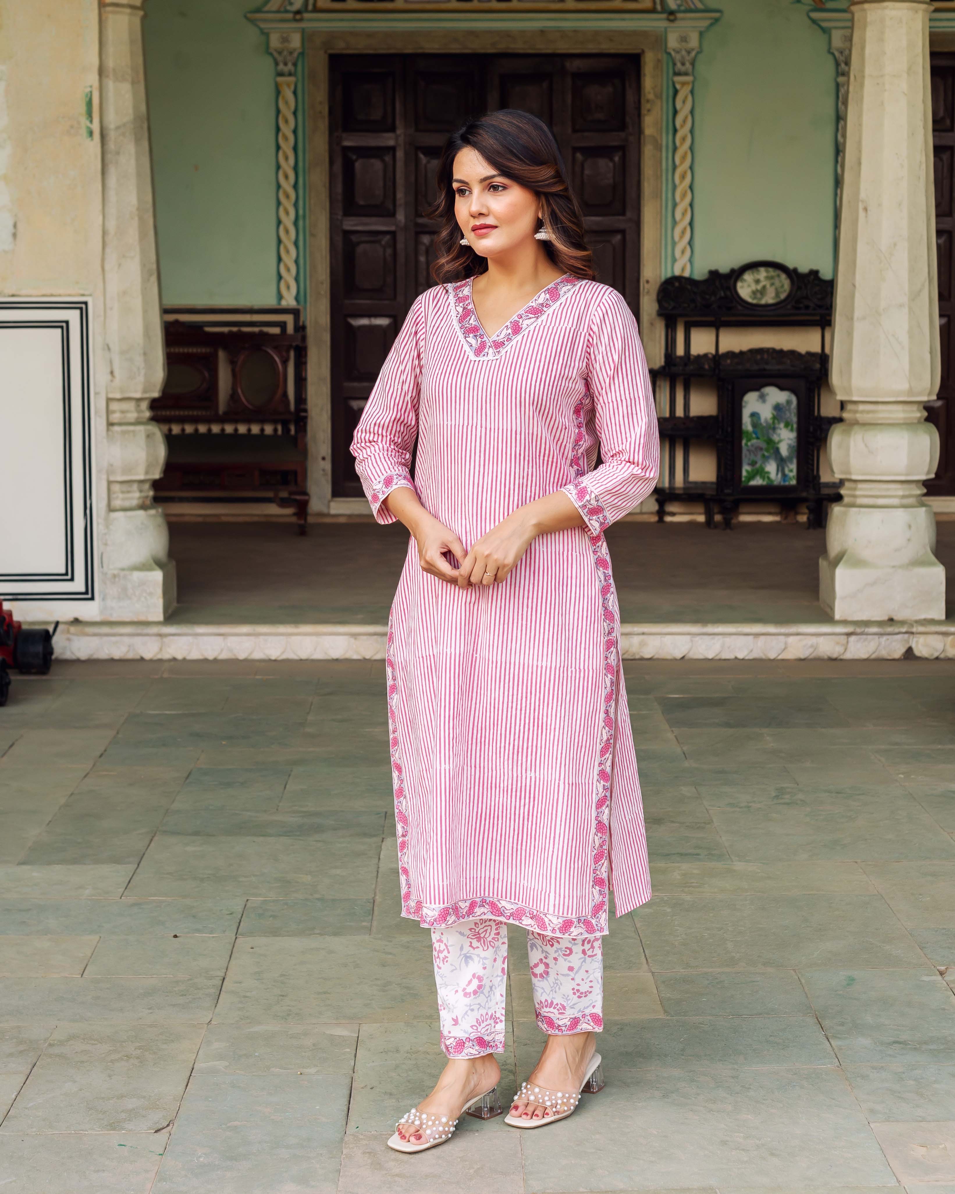 Full shot of woman in pink and white striped kurta set with floral block-print pants.