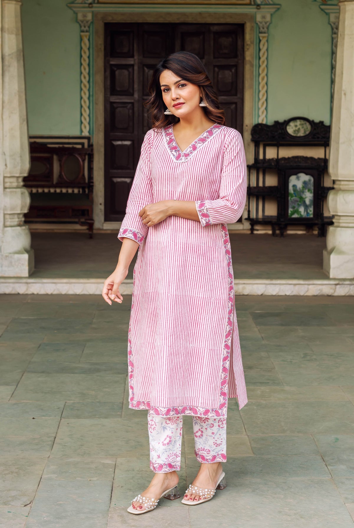 Full-length model in a white and pink striped ethnic kurta set with floral print pants.