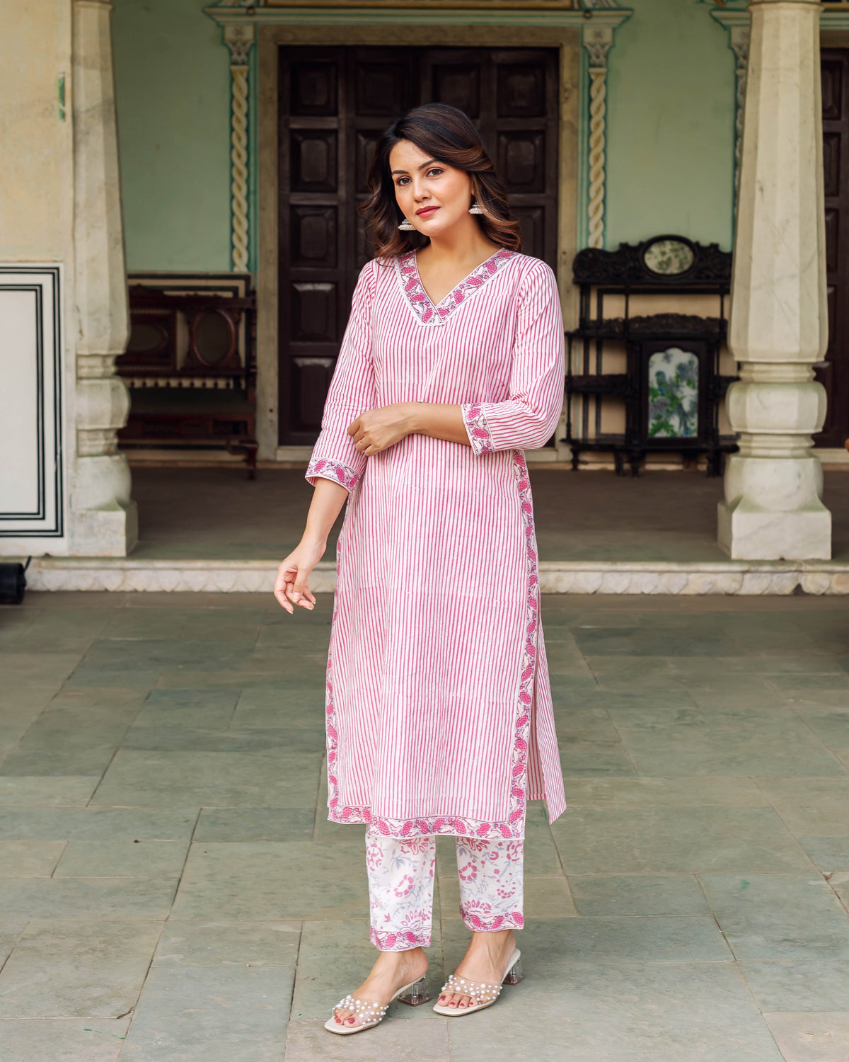 Full-length model in a white and pink striped ethnic kurta set with floral print pants.