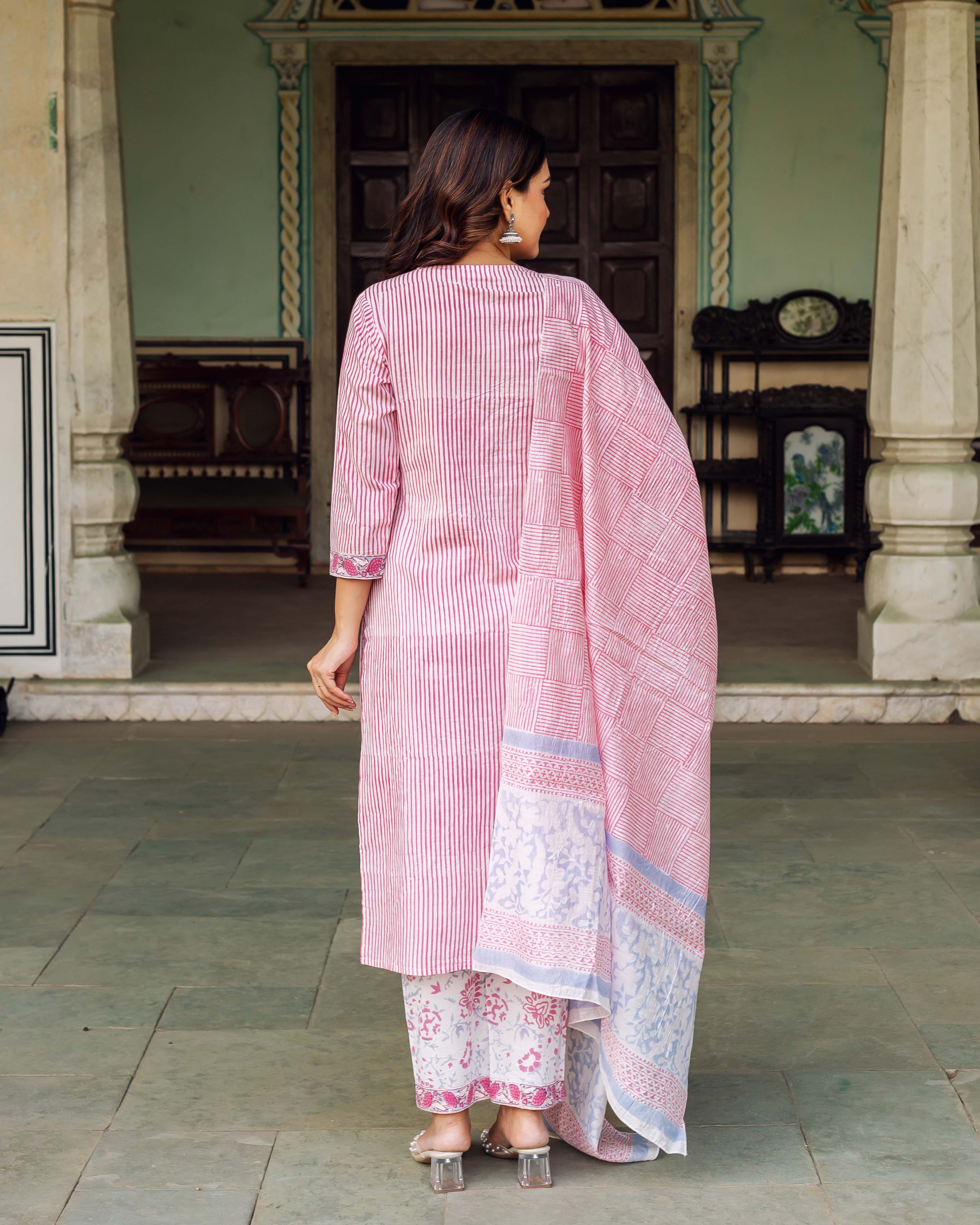 Woman in pink and white striped kurta and patterned pants with long dupatta.