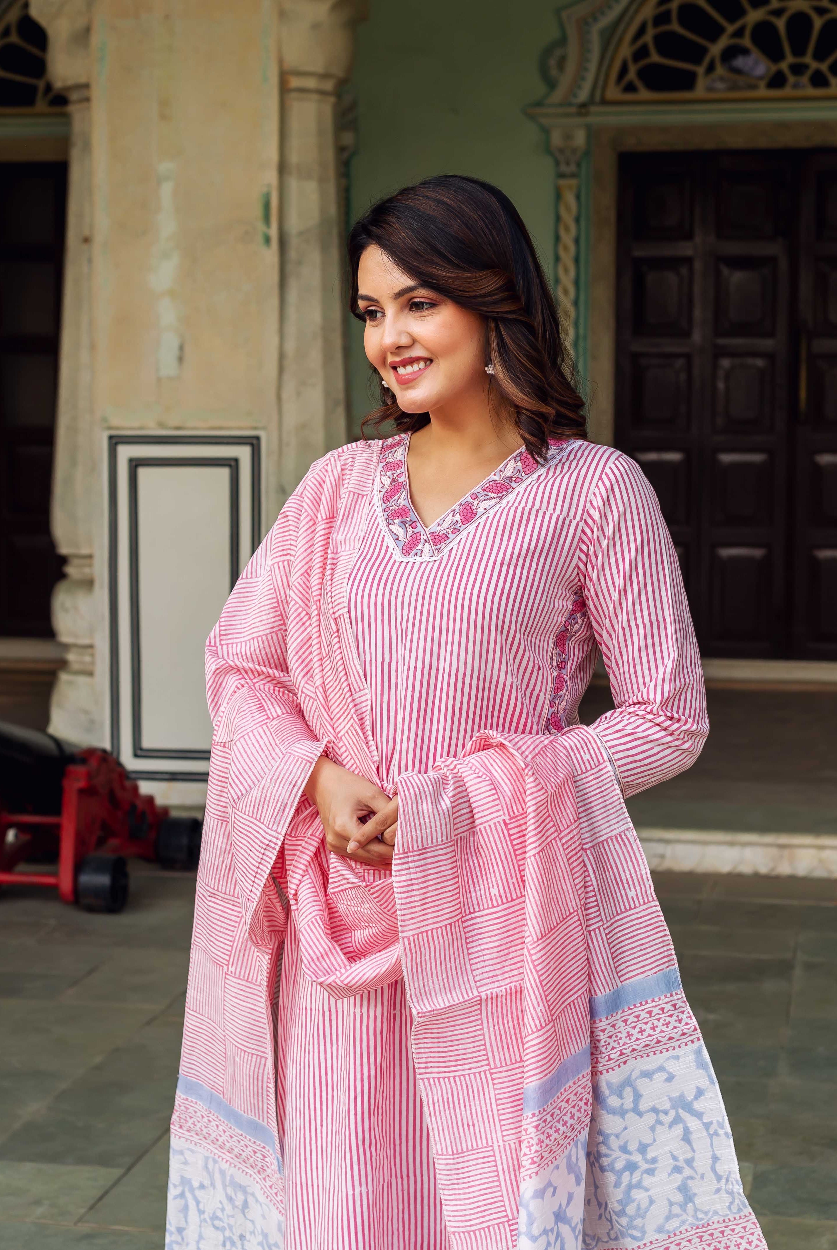 Smiling model in white and pink stripe kurta with embroidered neck and patterned dupatta.