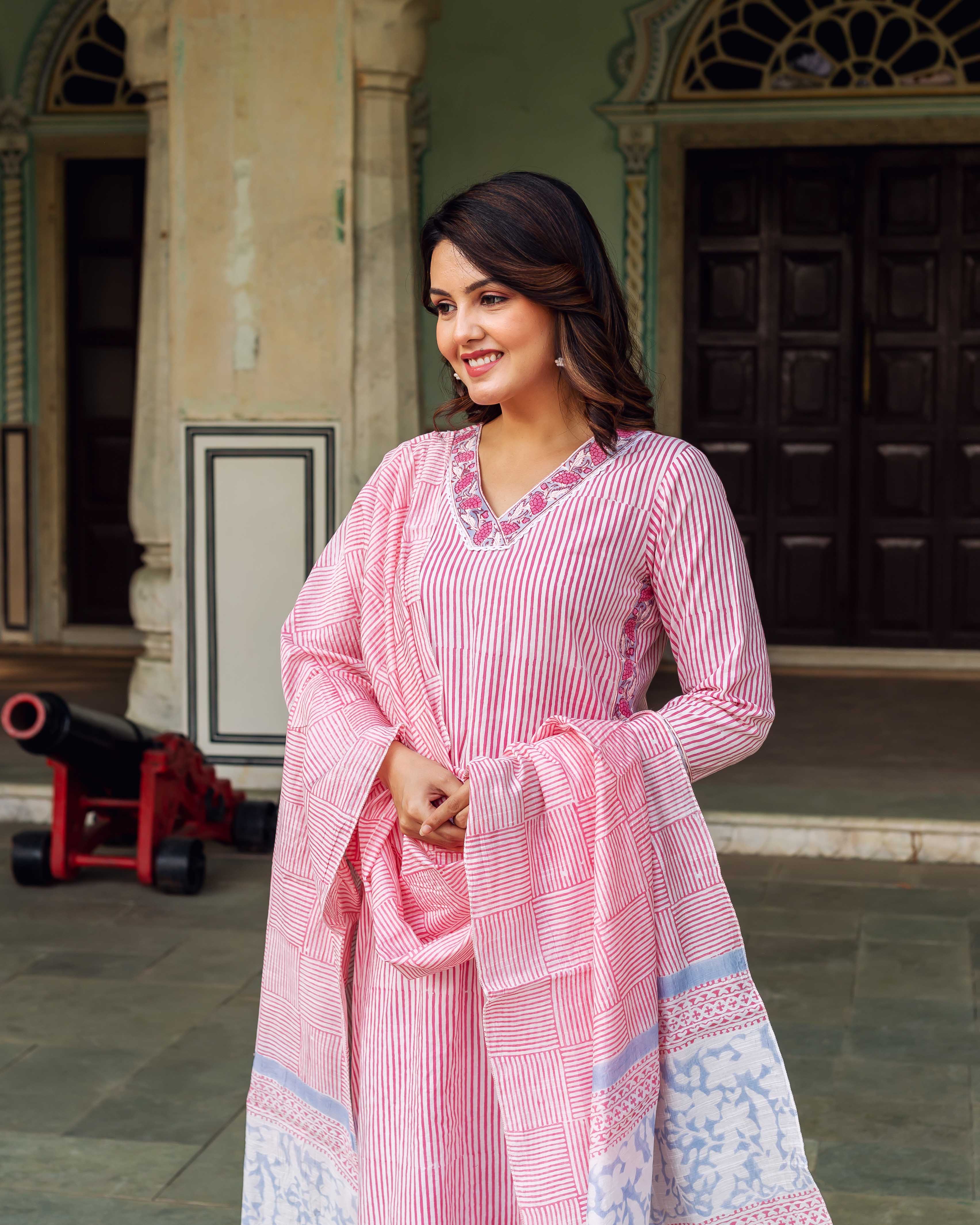 Smiling model in white and pink stripe kurta with embroidered neck and patterned dupatta.