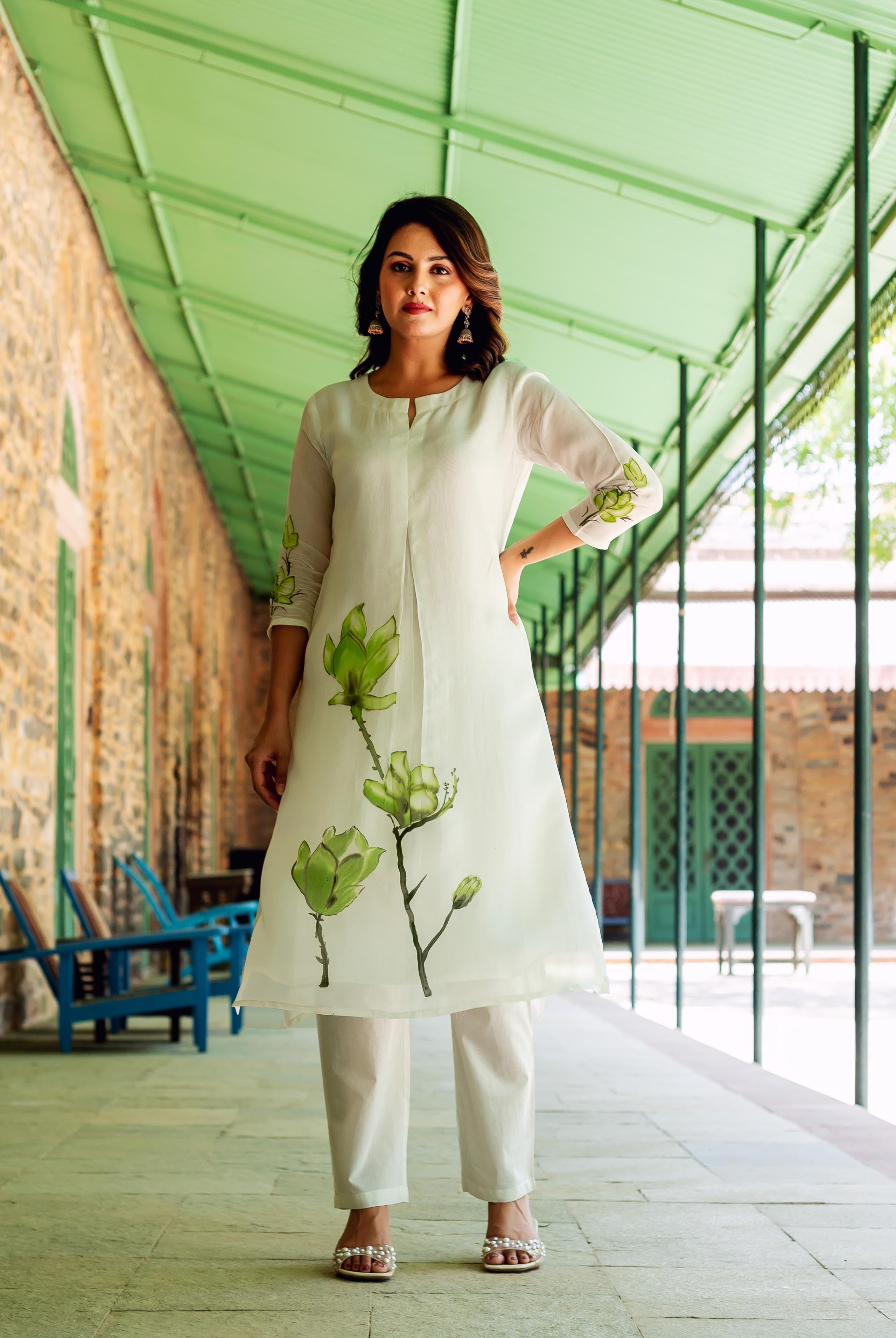 A woman models a white kurta with green floral print.
