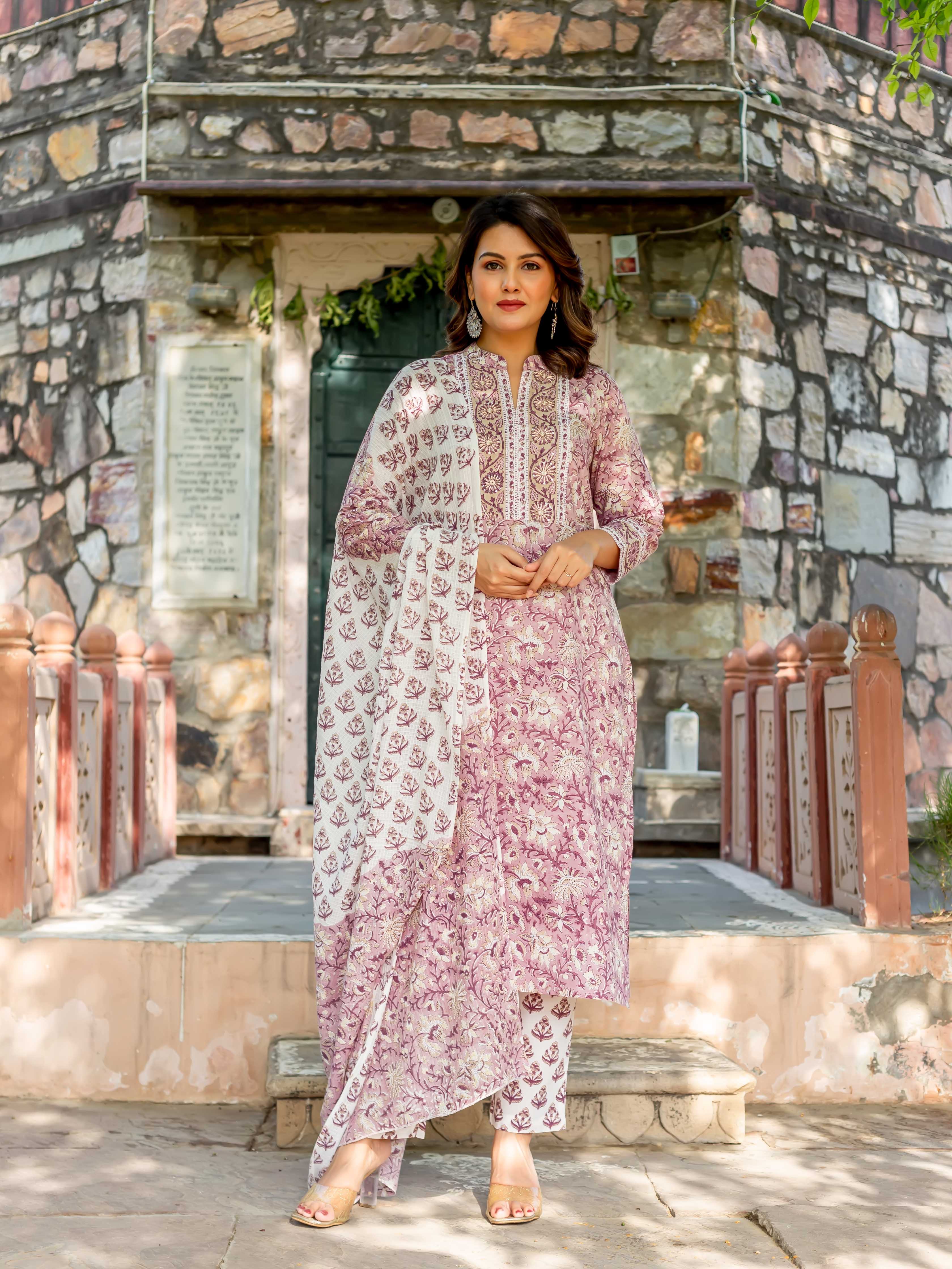 Woman models old rose and white hand-block-printed cotton kurta set with dupatta.