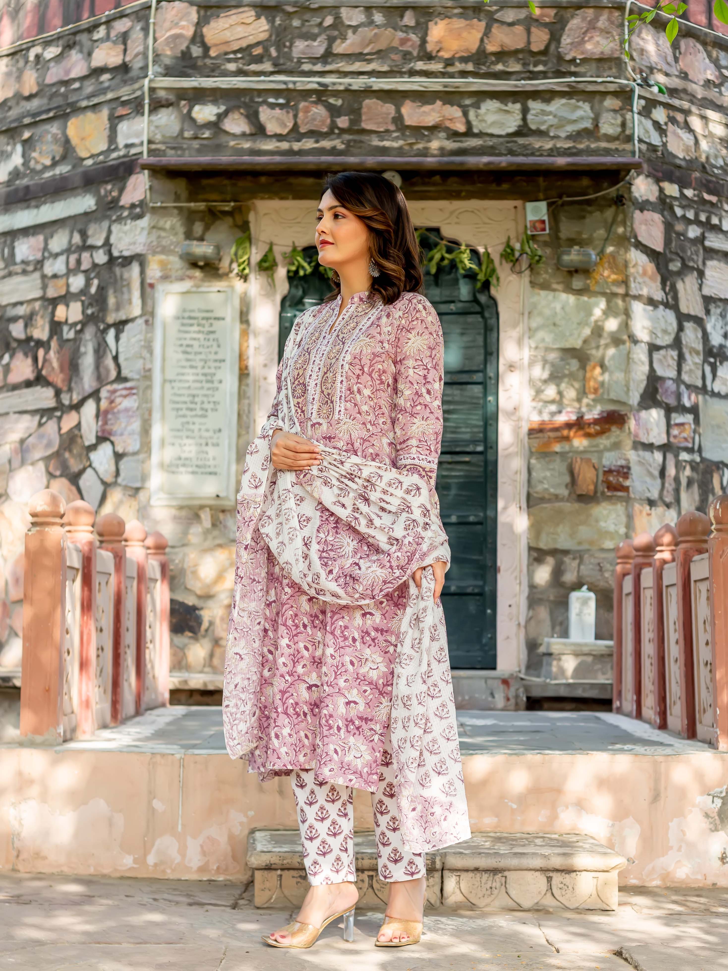 Woman standing in a light rose and white floral-printed ethnic kurta set outdoors.