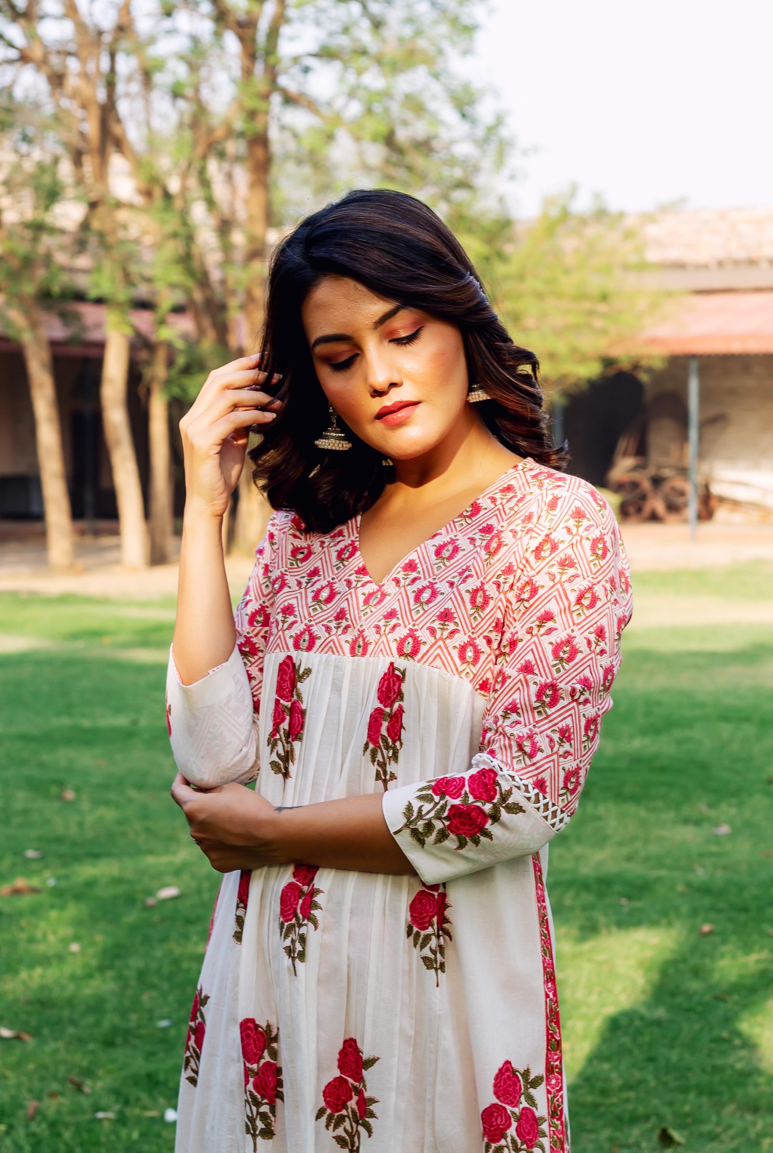 Front view of woman in white and red hand-block printed cotton kurta with rose motifs.