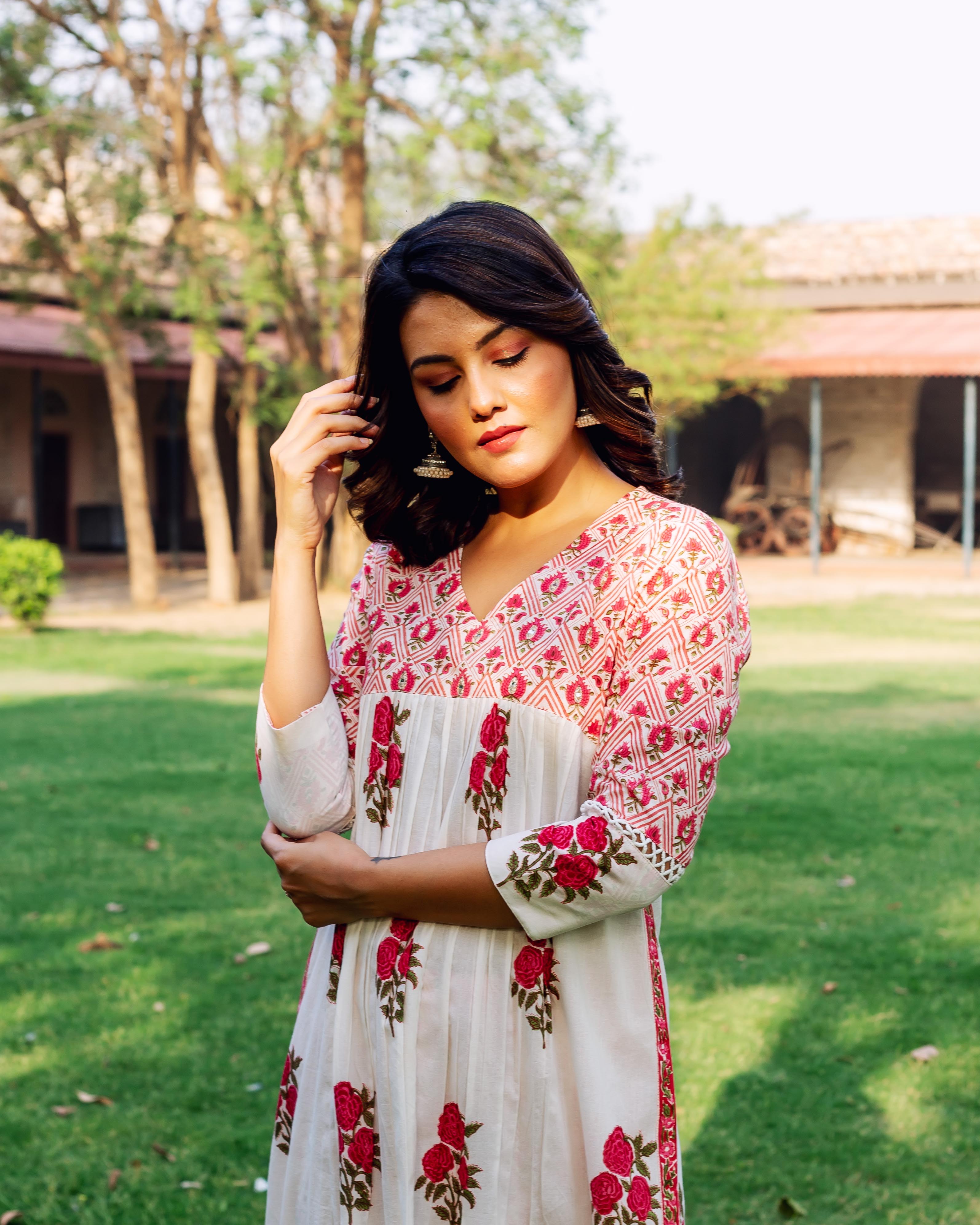Front view of woman in white and red hand-block printed cotton kurta with rose motifs.