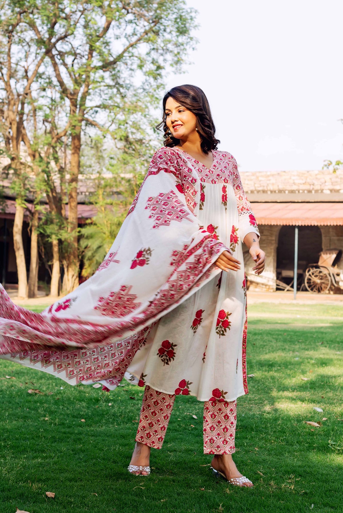 Model in a white and red hand-block-printed cotton kurta set with a flowing dupatta.