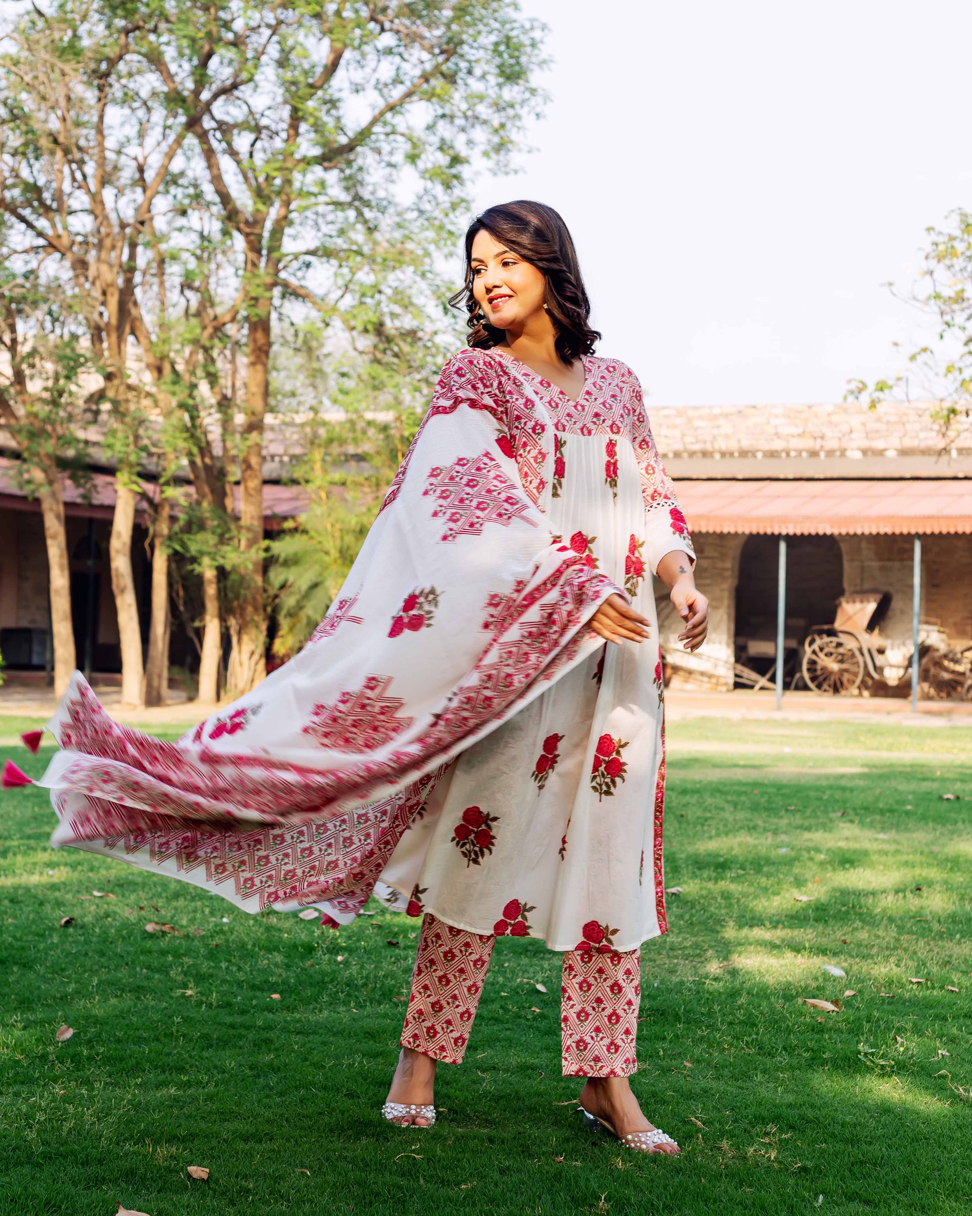 Model in a white and red hand-block-printed cotton kurta set with a flowing dupatta.
