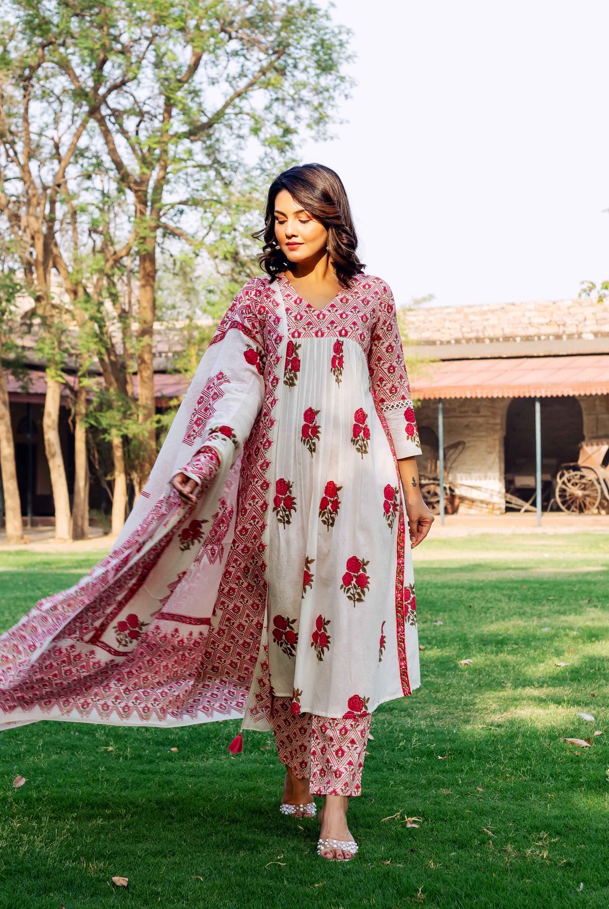 Model wearing a white and red hand-block printed kurta set with floral and geometric patterns.