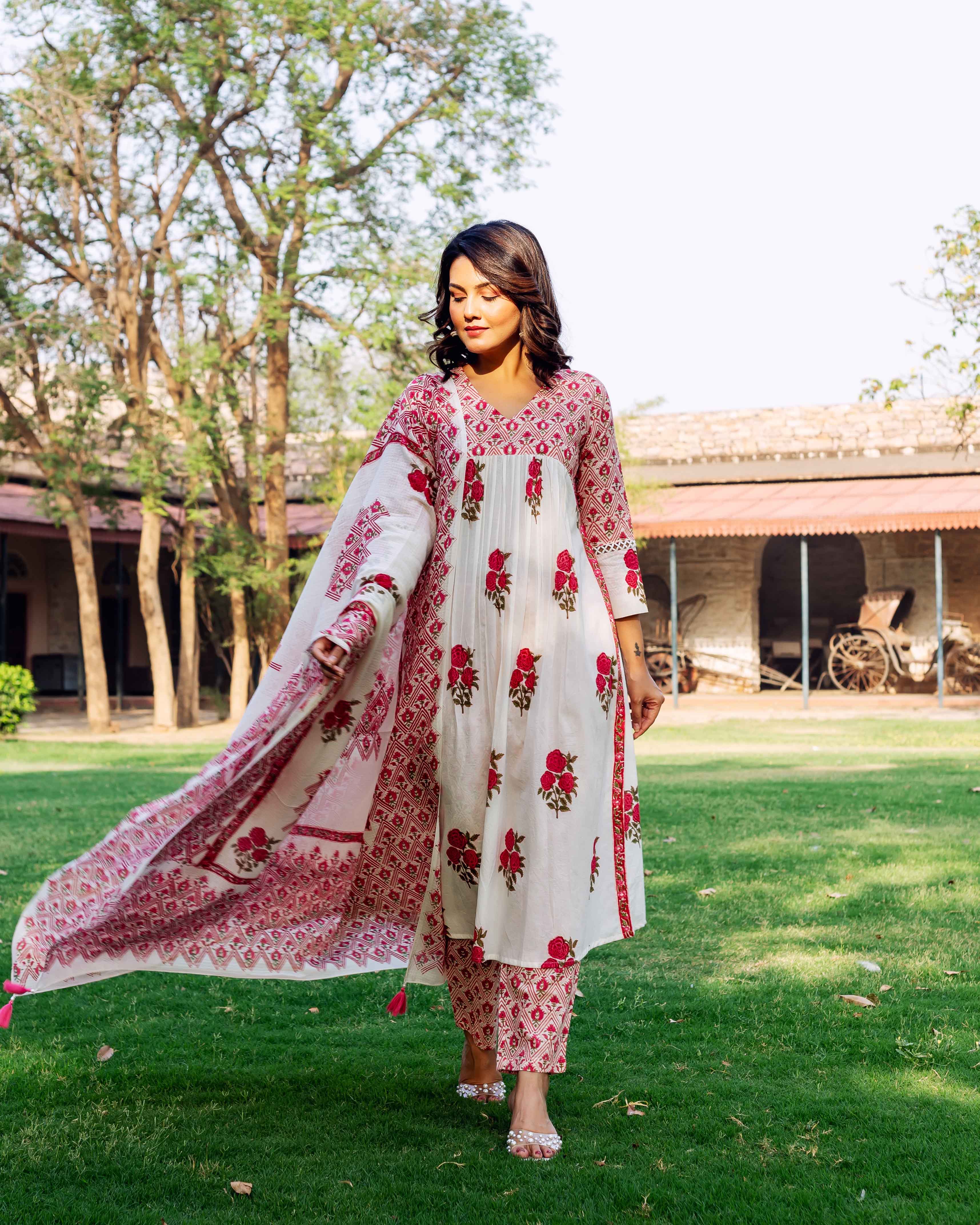 Model wearing a white and red hand-block printed kurta set with floral and geometric patterns.
