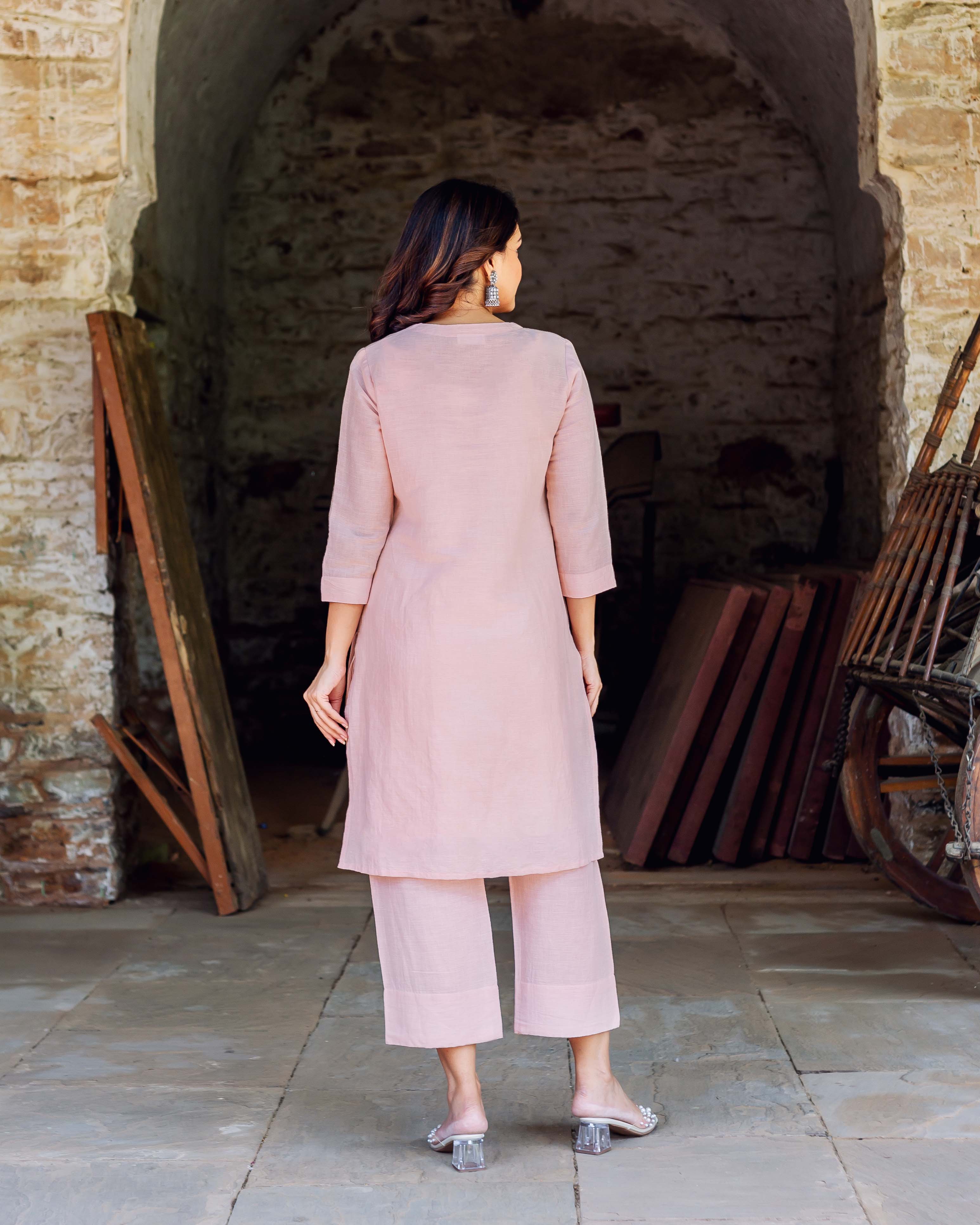 Back view of model wearing a pink linen kurta and matching cropped pants.