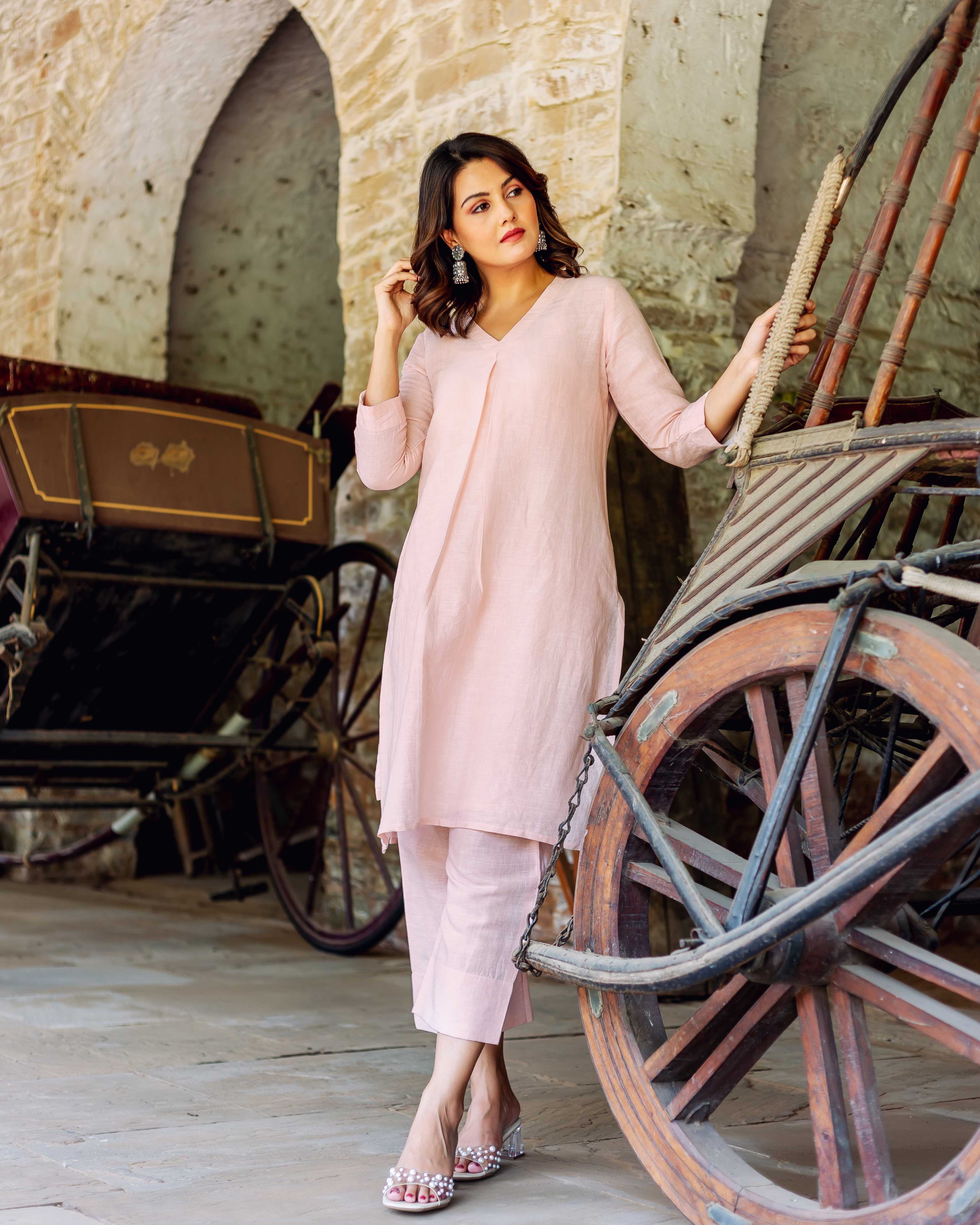 Full look of a model wearing a plain pink linen co-ord set, tunic and cropped pants.