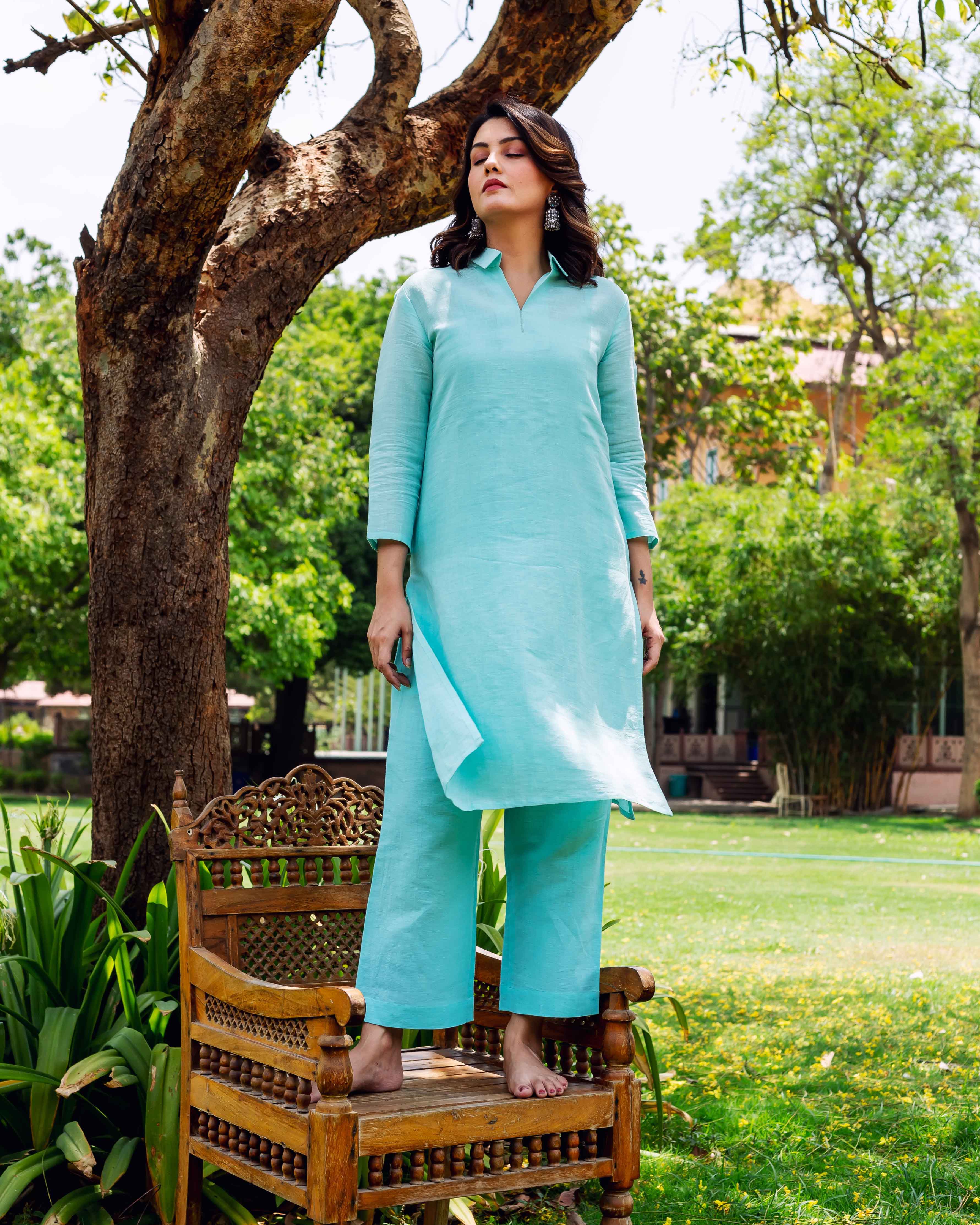 Front full look of a woman in a plain bright sky blue linen kurta and pants.