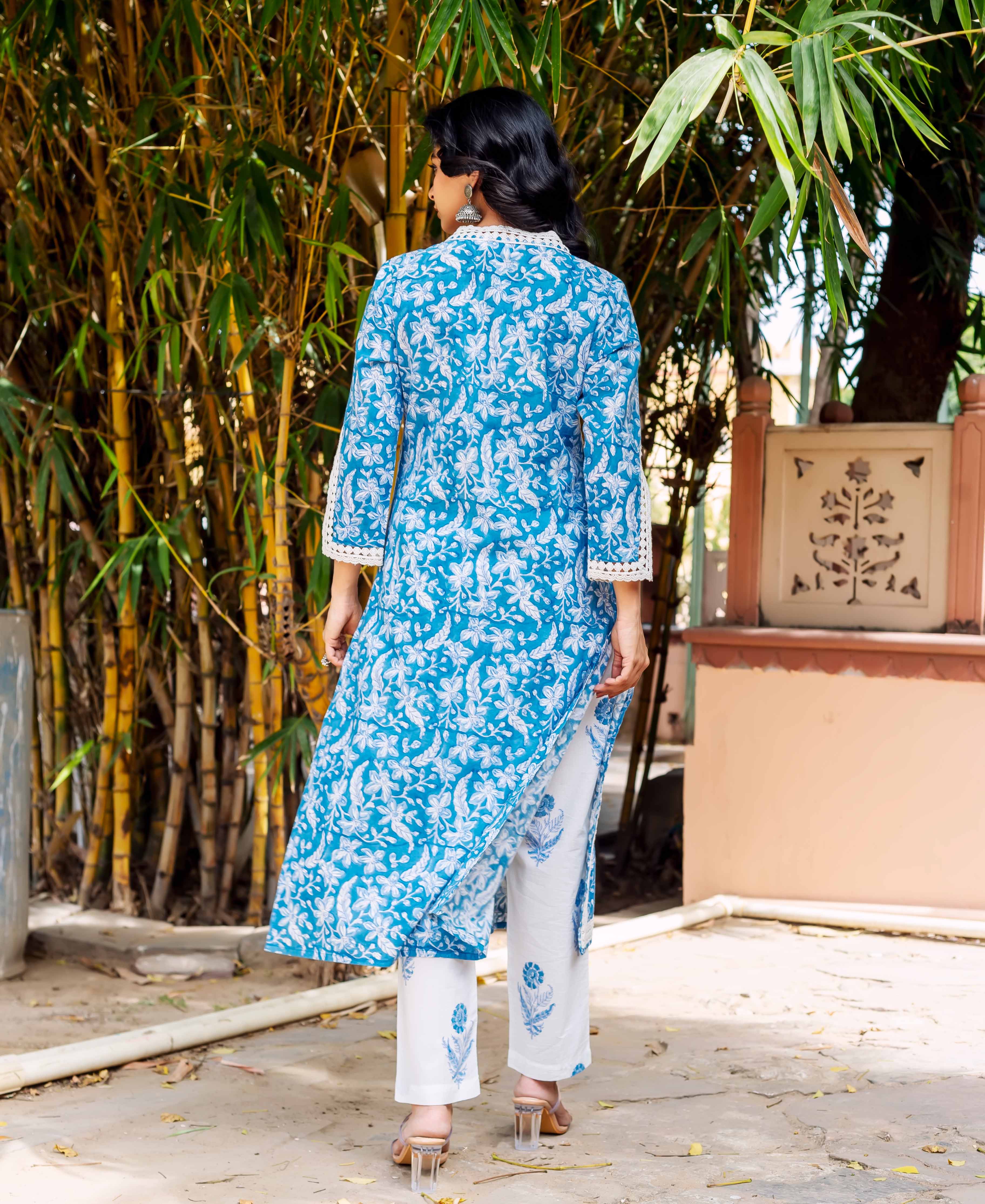 Back view woman in blue and white floral block print kurta, lace trim, white printed pants.