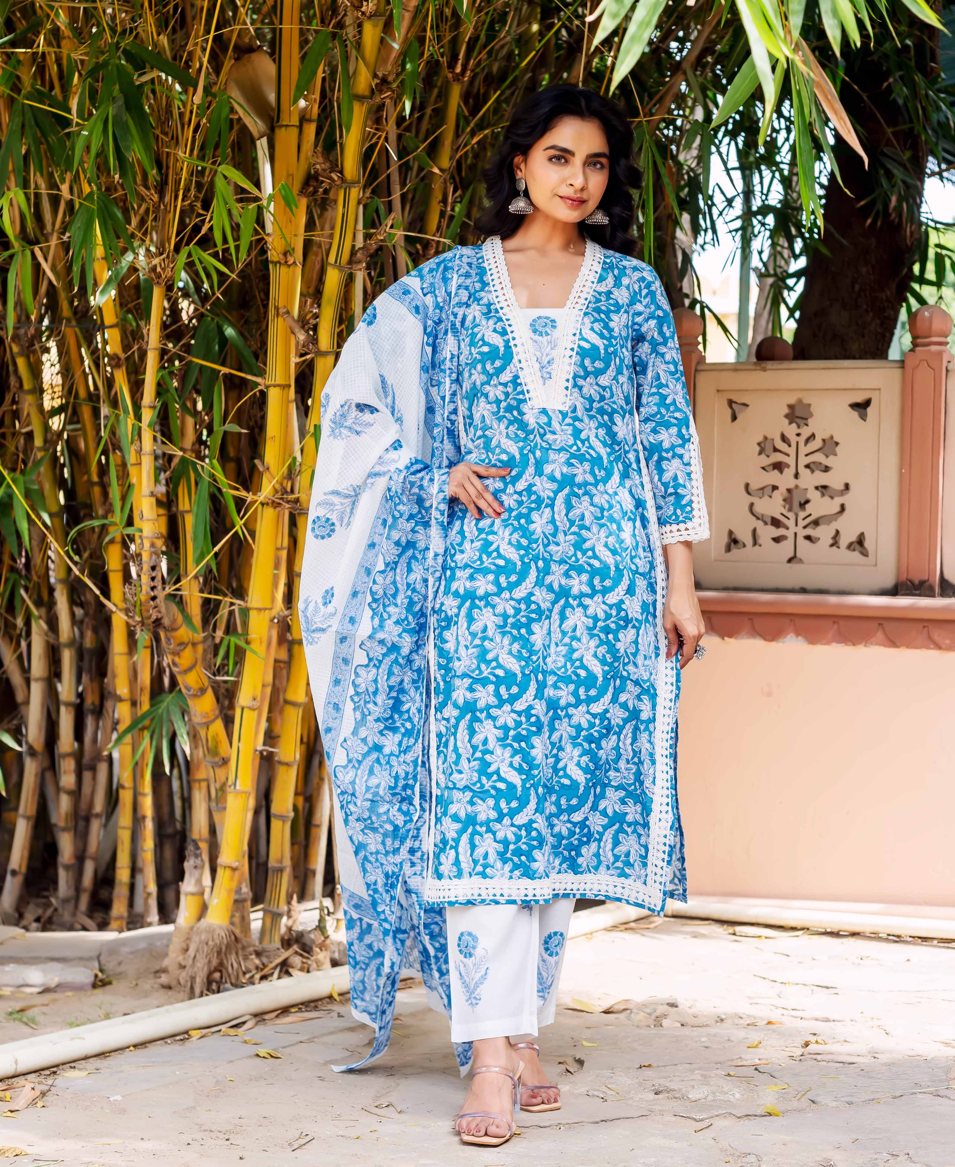 Front view of model in blue and white hand-block-printed floral kurta set with lace trim.