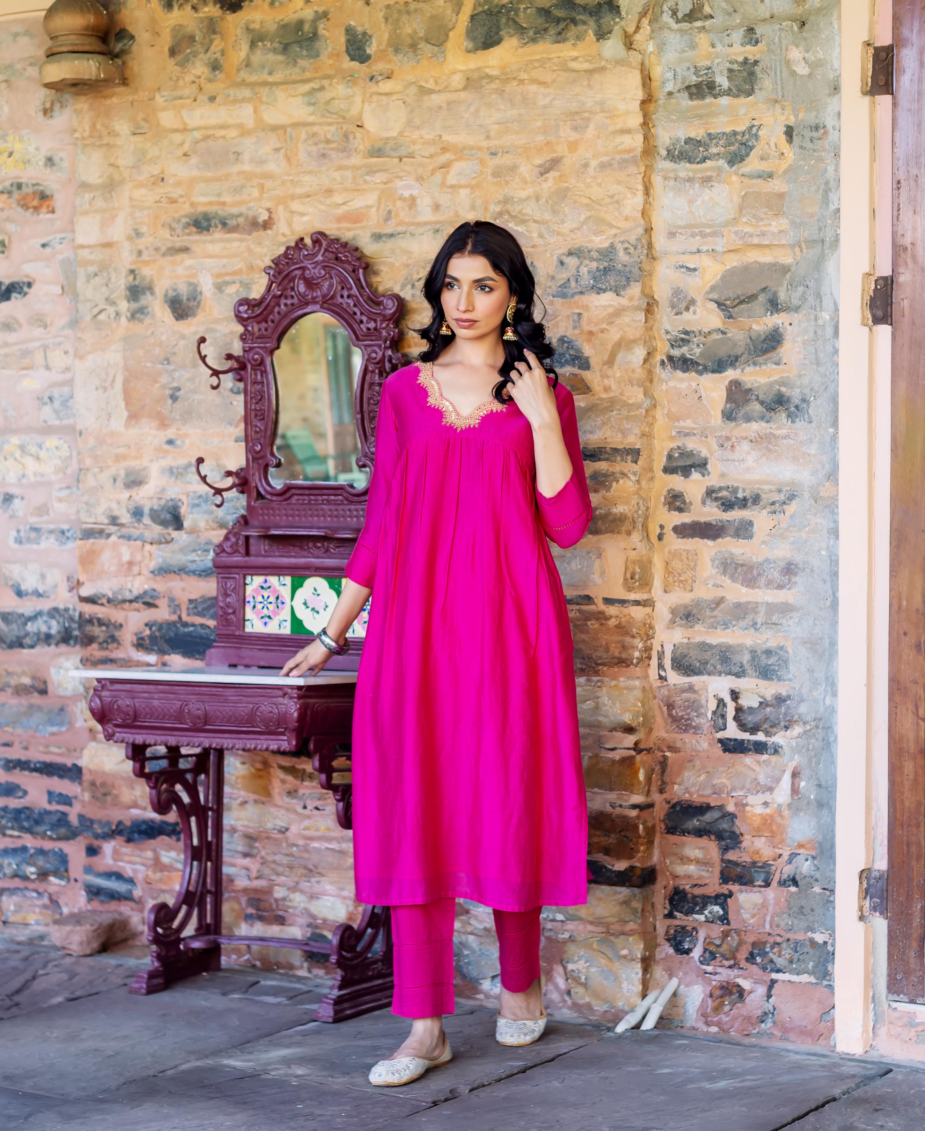 Model in a radiant pink Chanderi silk kurta with a gold embroidered V-neckline.