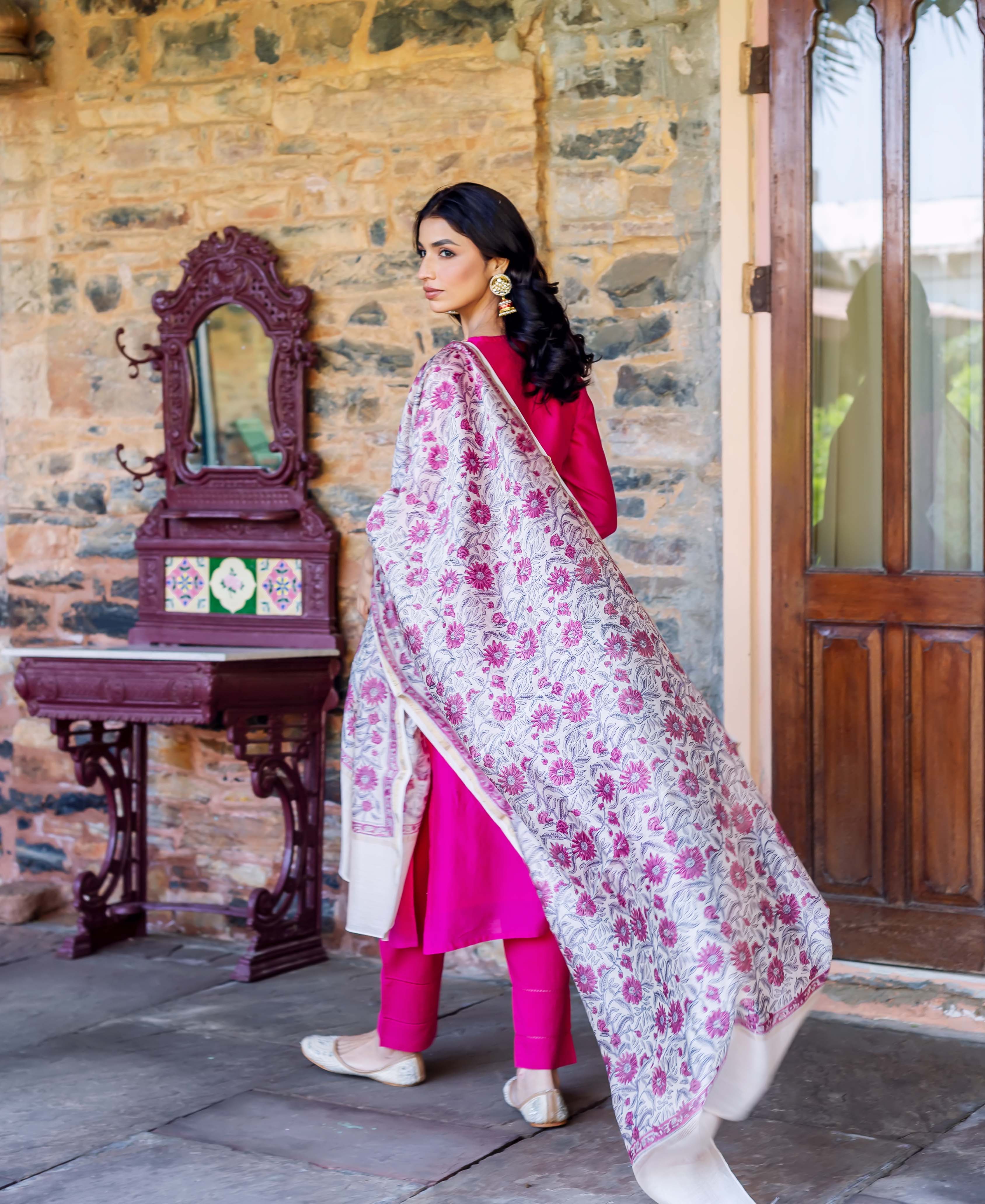 Back view of model in radiant pink kurta set, cream and fuchsia floral block-printed dupatta.