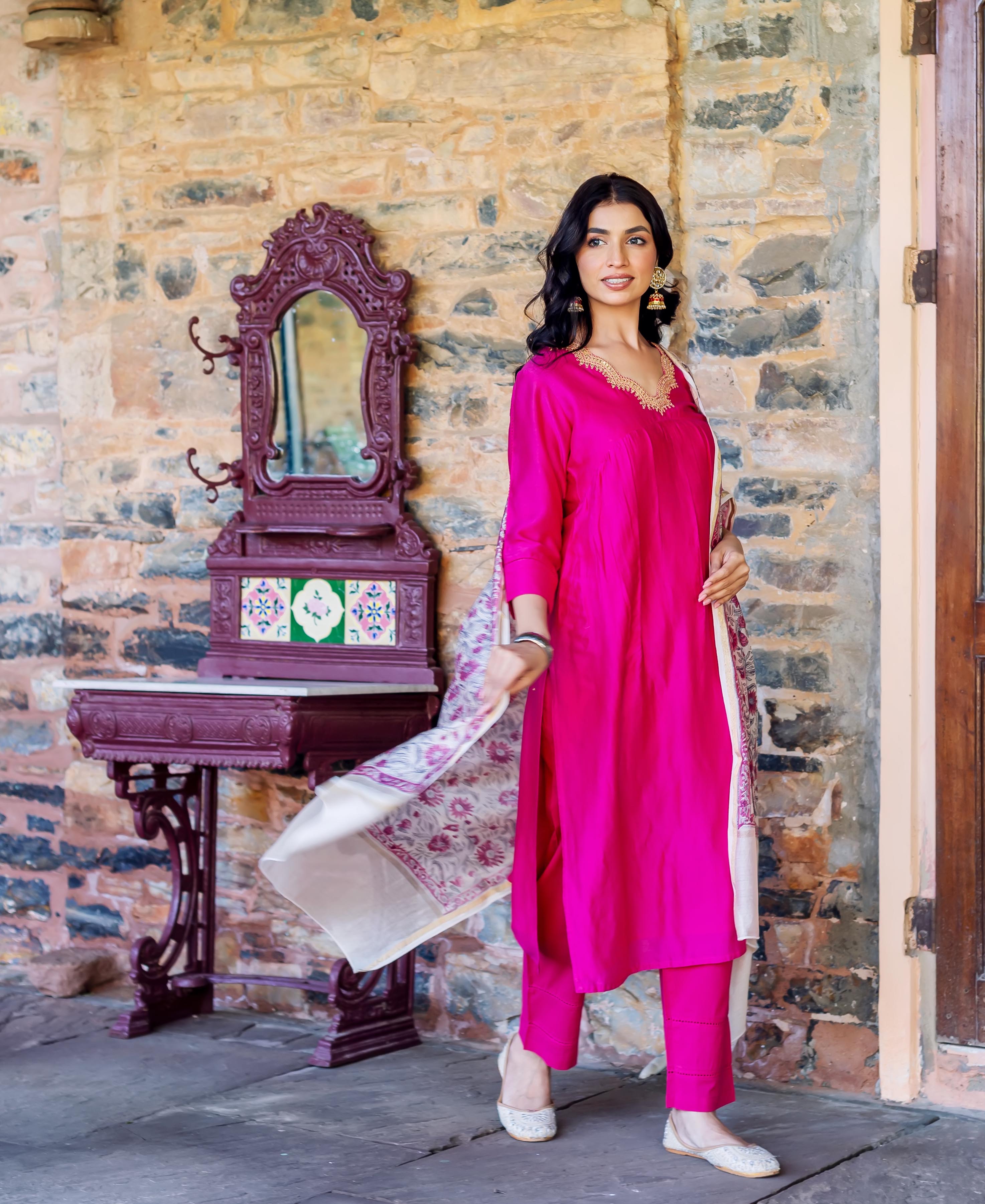 Model in radiant pink kurta set with golden V-neck and off-white floral hand-block printed dupatta.