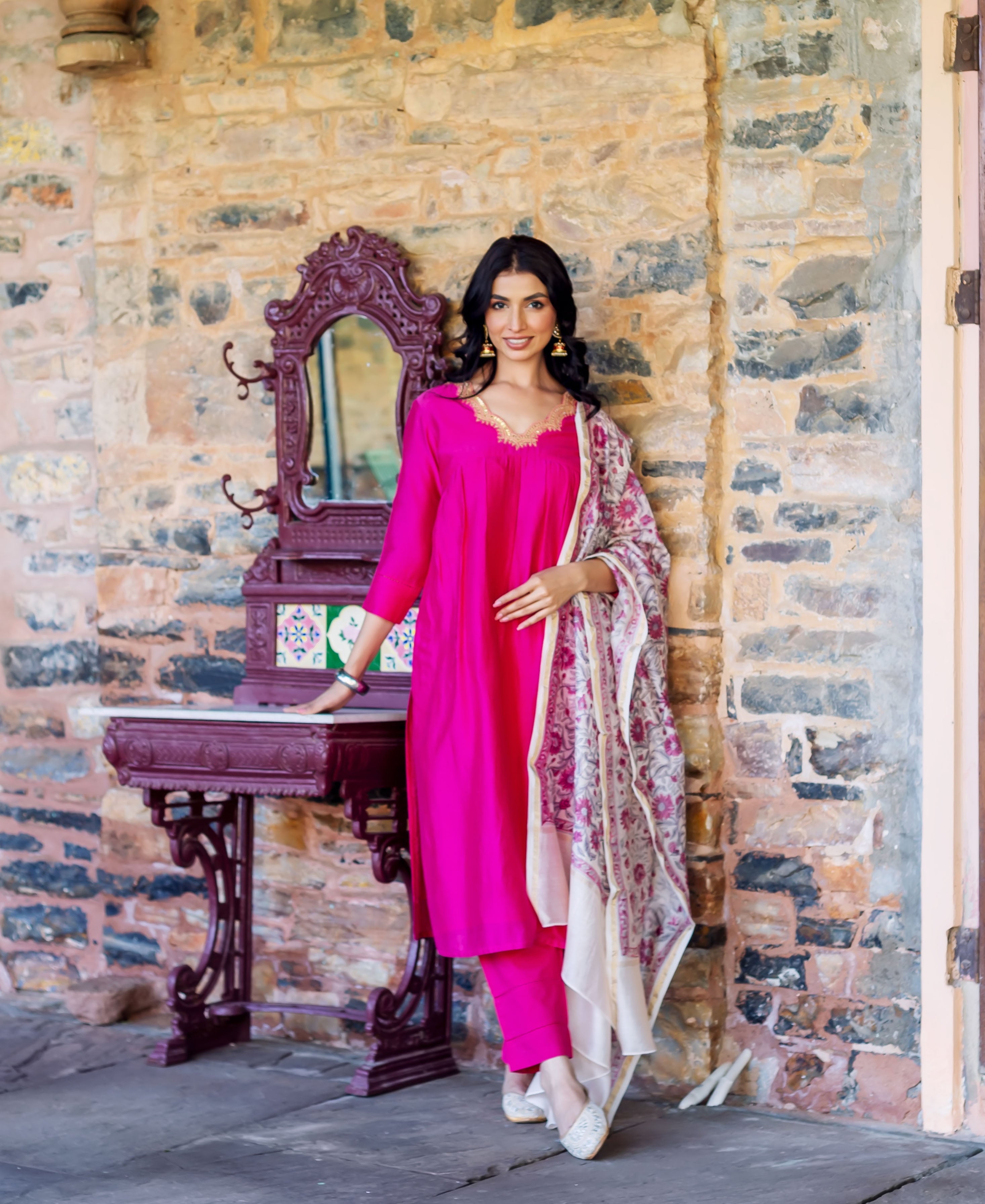 Full shot of model wearing a radiant pink kurta, matching pants, and floral printed dupatta.