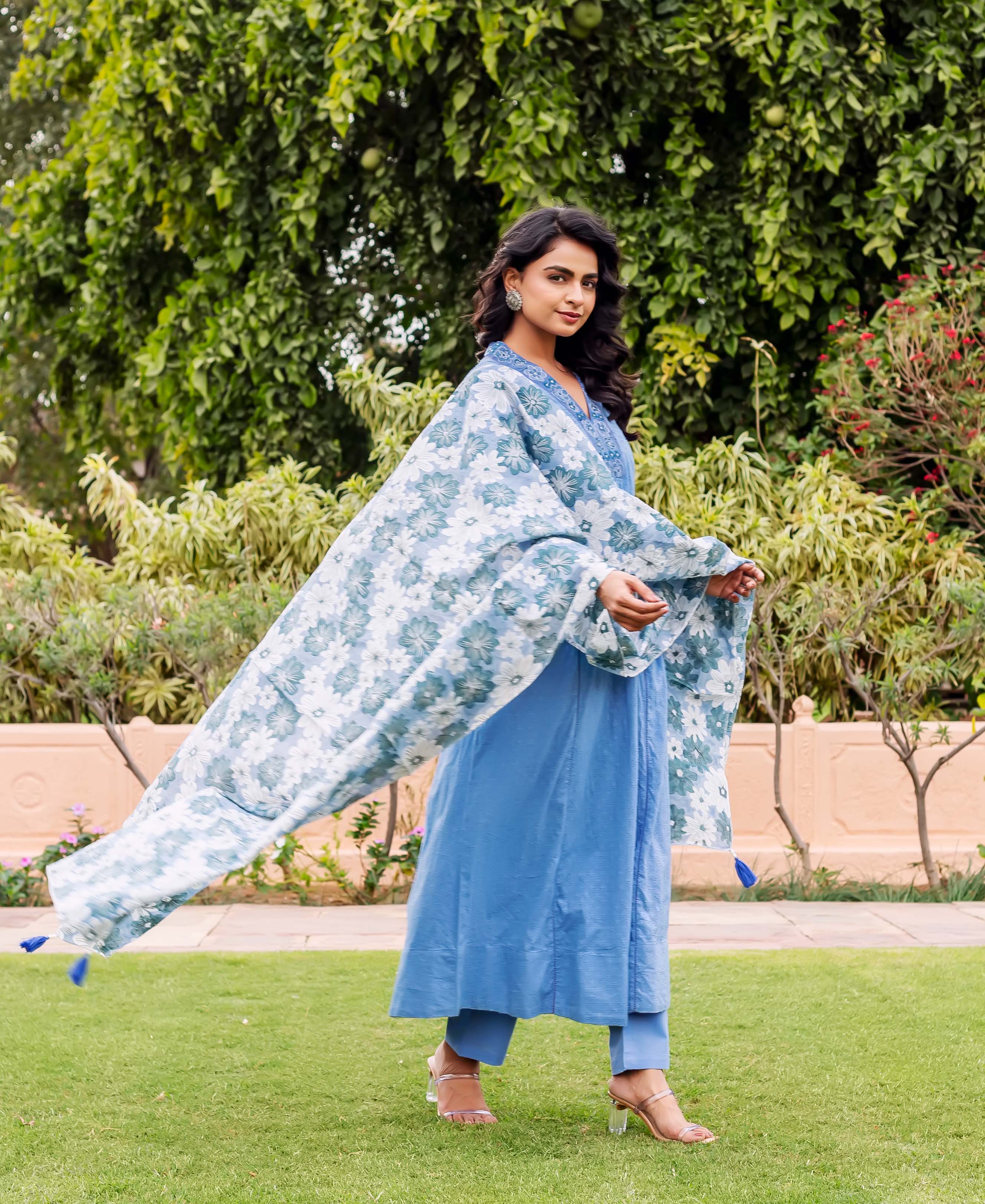 Model in full-length sky blue Anarkali kurta set, with a flowing blue and white floral dupatta.