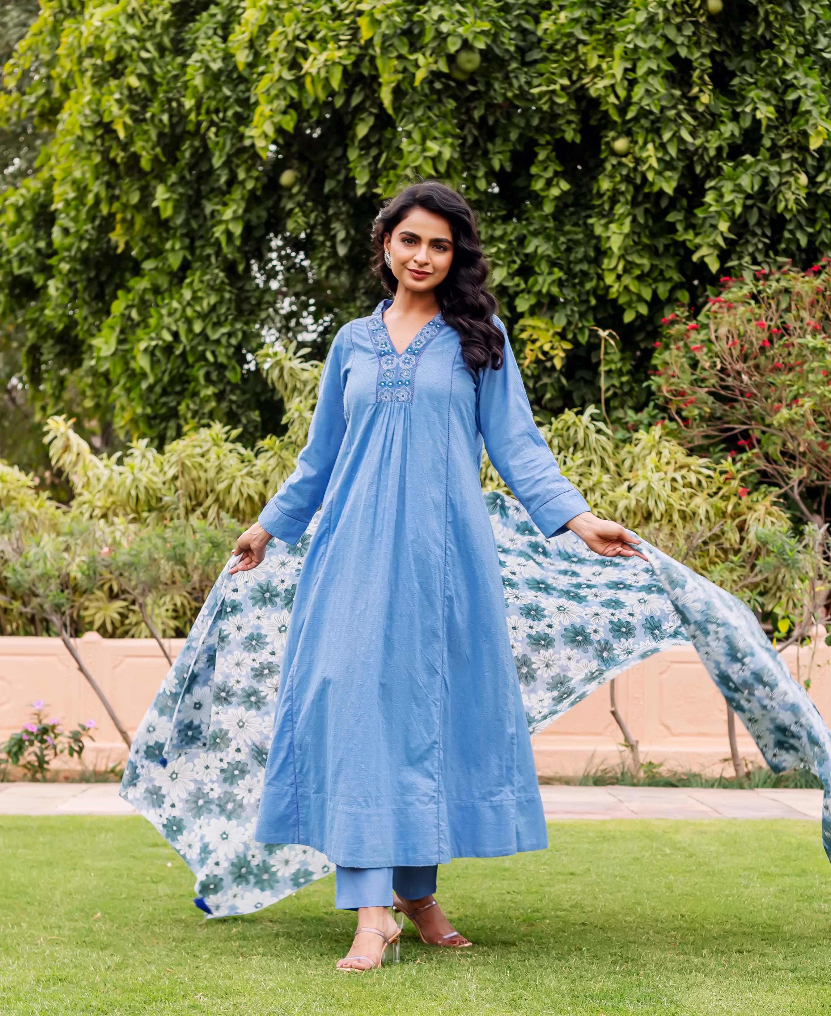 Model wears sky blue embroidered Anarkali kurta set with a flowing floral dupatta.