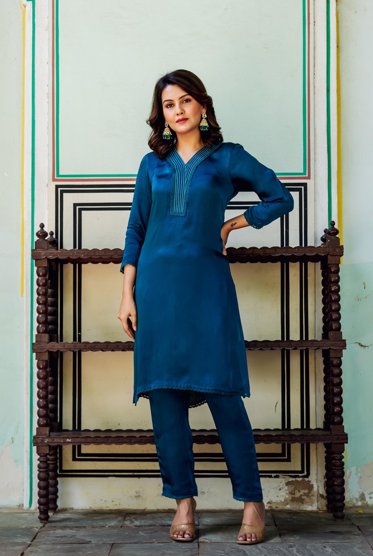 Full-length model in royal blue satin kurta set with embroidered V-neck and matching pants.