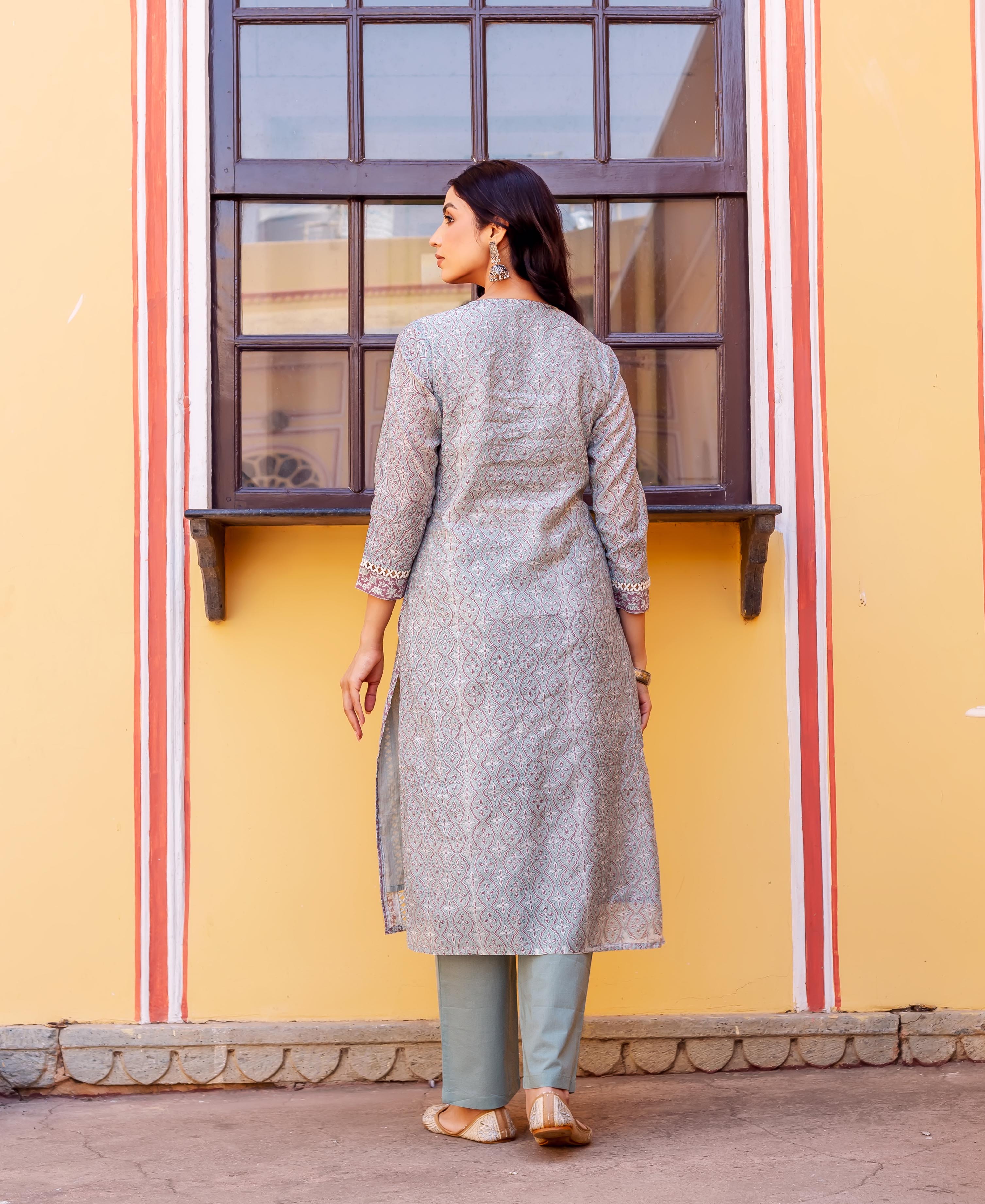 Model from back in grey block-printed kurta and light green pants, looking left.