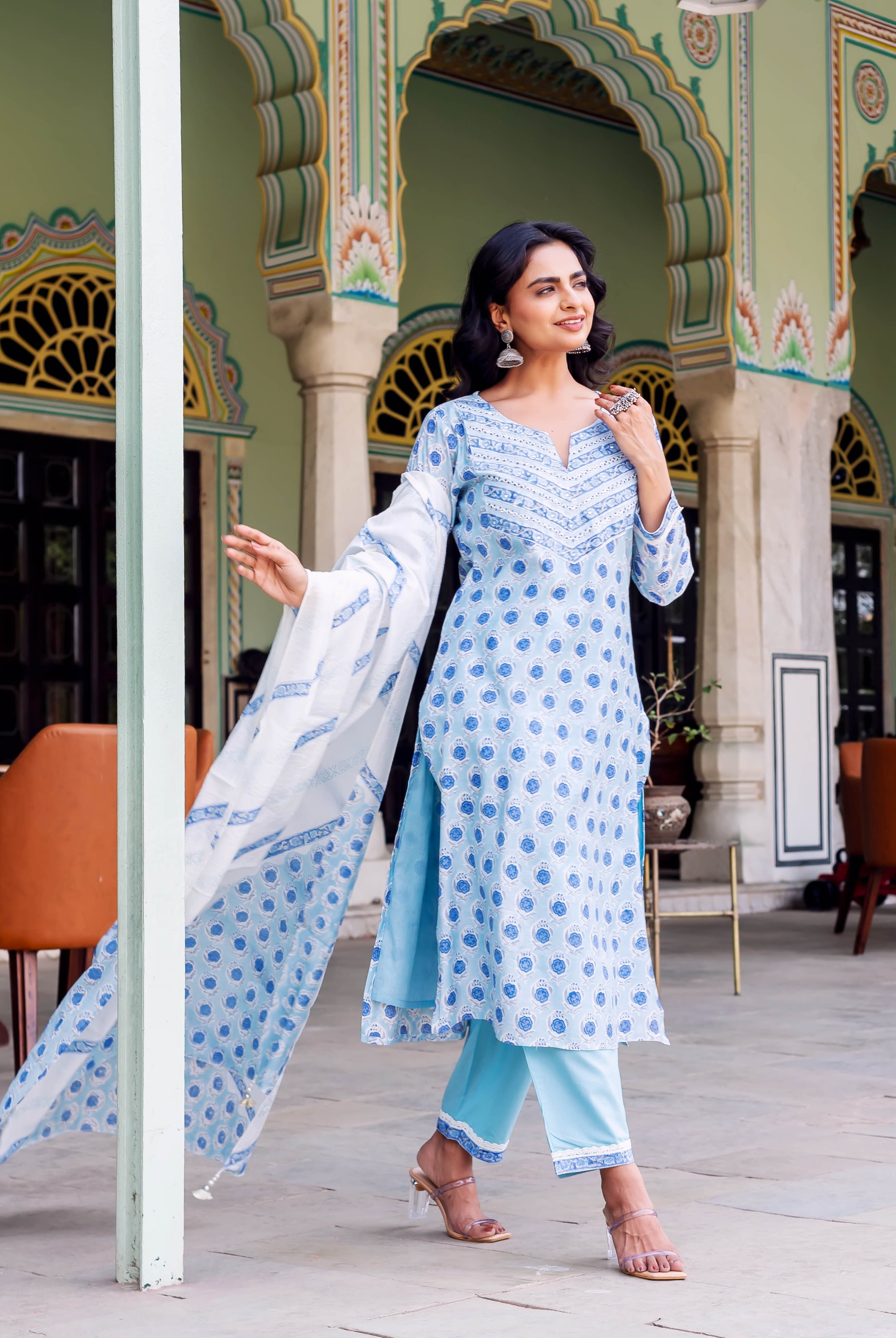 Woman wearing light blue hand-block printed kurta set with blue motifs and white dupatta.