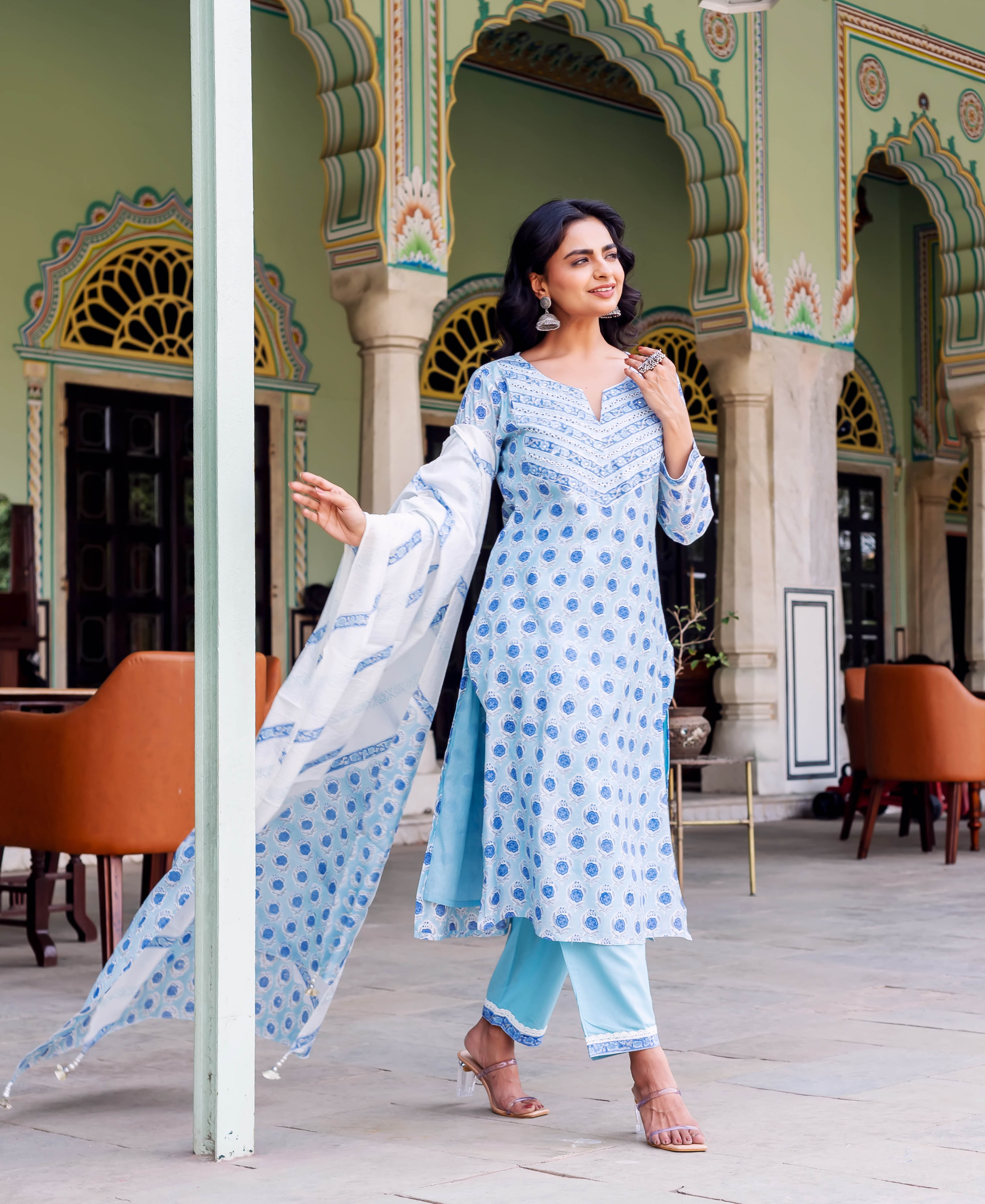 Woman wearing light blue hand-block printed kurta set with blue motifs and white dupatta.