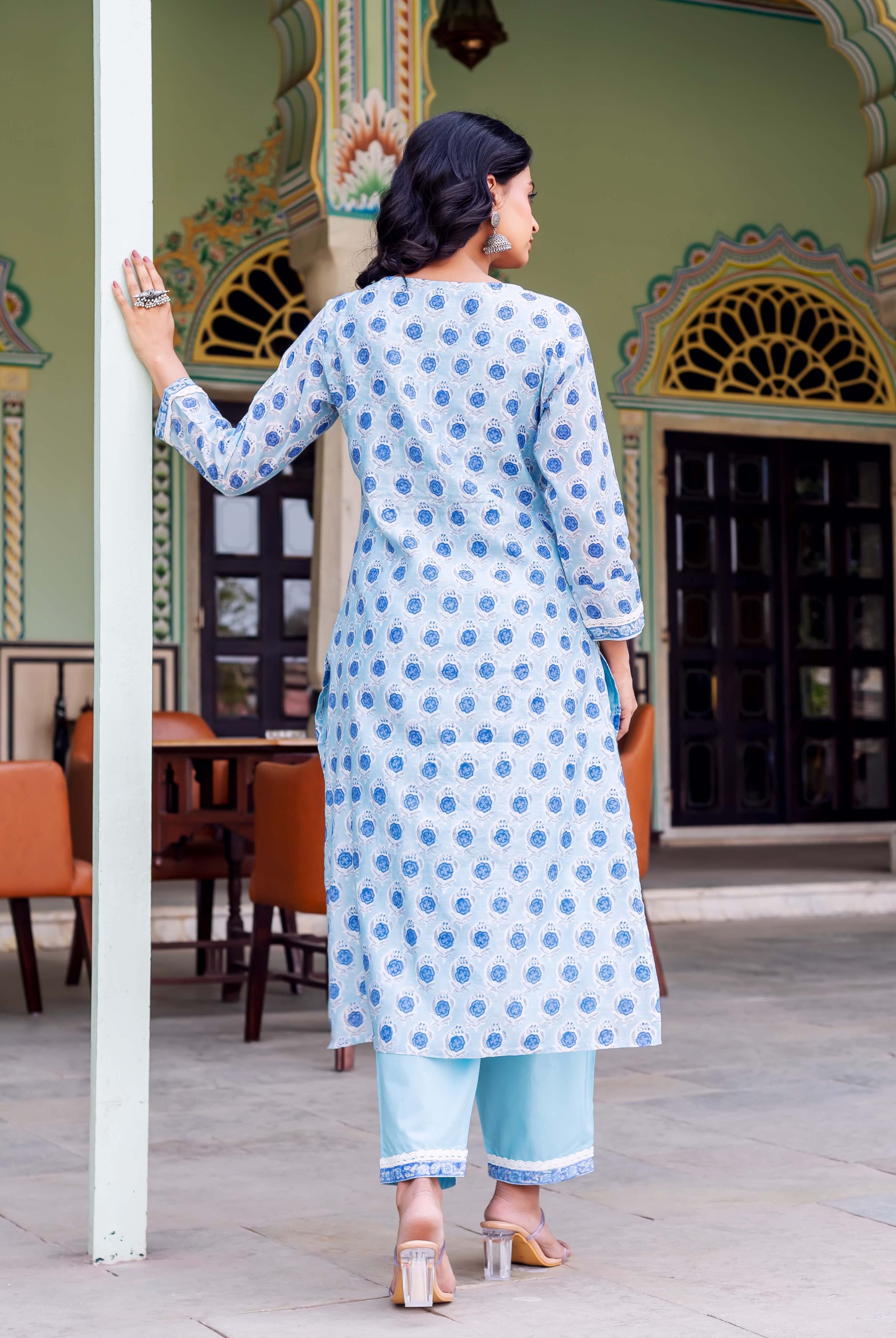 Woman's back in light blue block-printed kurta with blue floral motifs and matching pants.