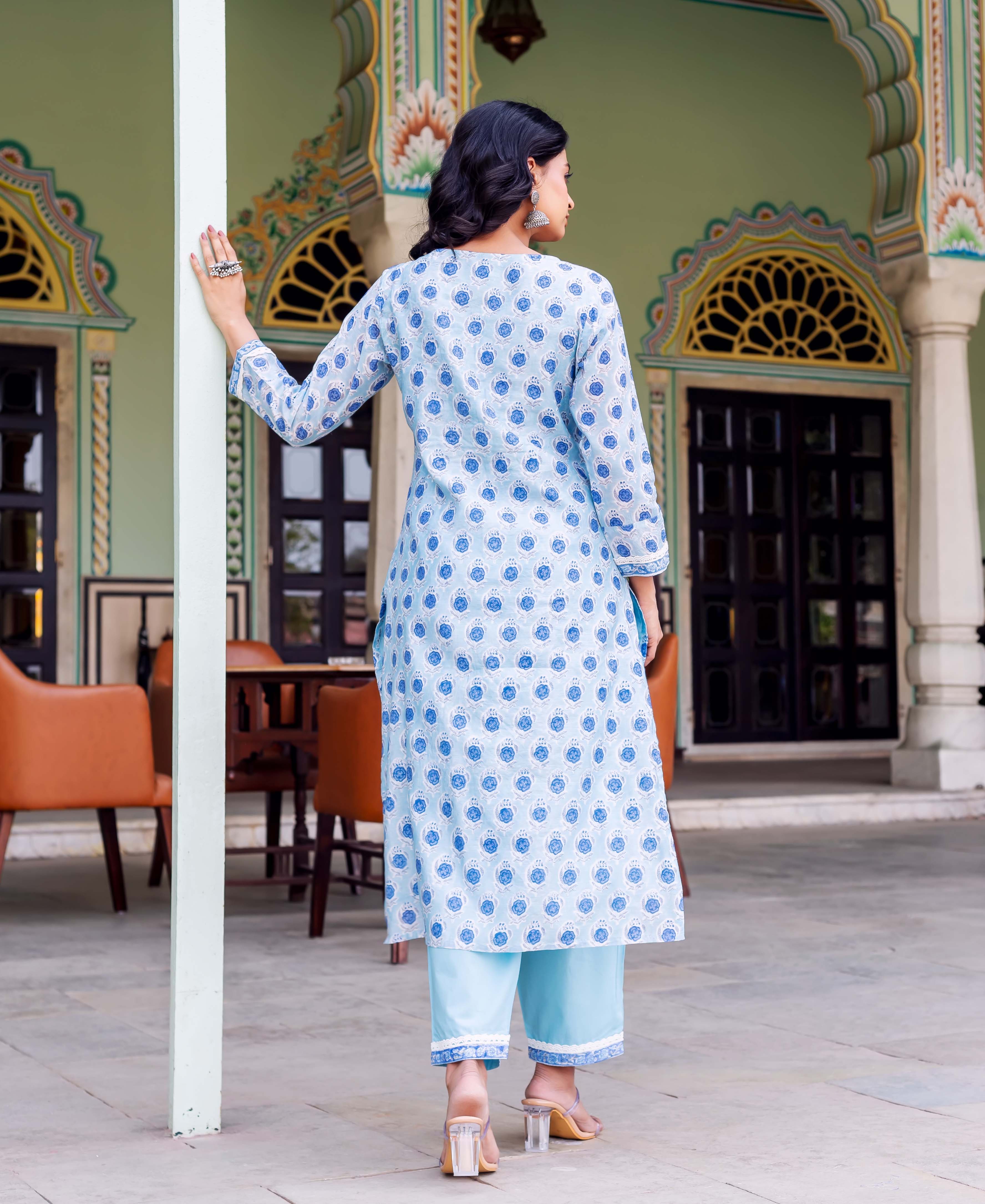Woman's back in light blue block-printed kurta with blue floral motifs and matching pants.