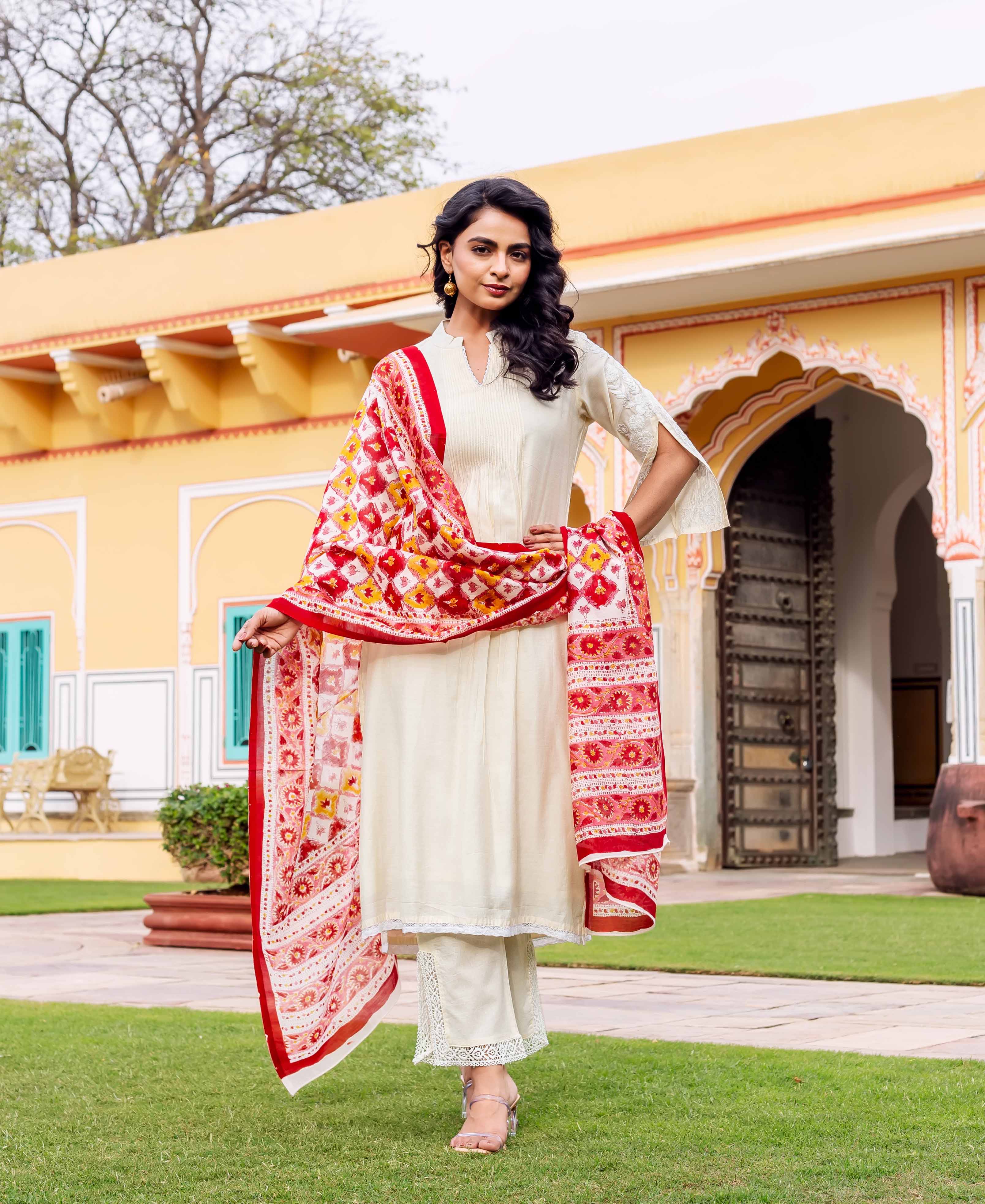 Antique white silk kurta with red, orange, and yellow hand-block-printed dupatta and intricate lace details.