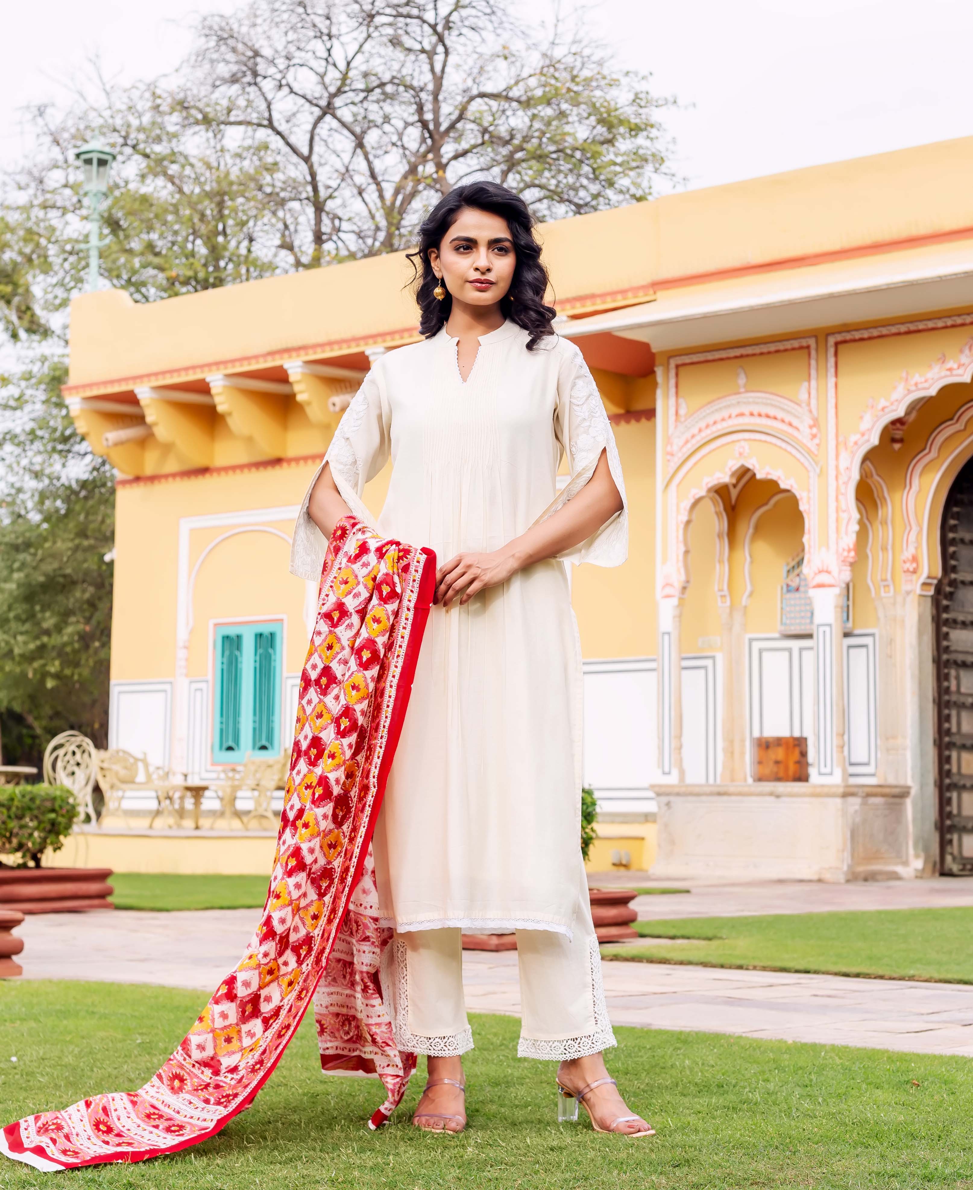 Front view of model wearing antique white kurta set with red hand-block printed dupatta.
