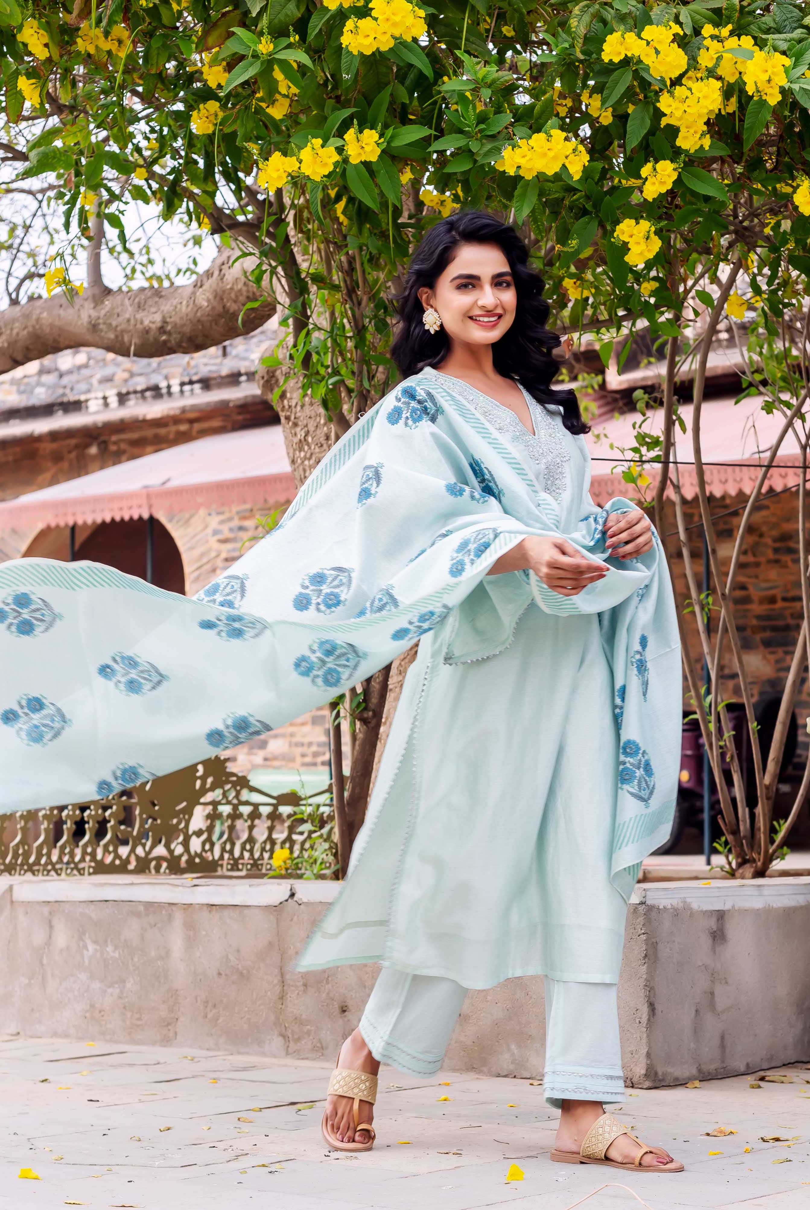 Model standing in mint chanderi silk kurta set with blue hand-block print dupatta.