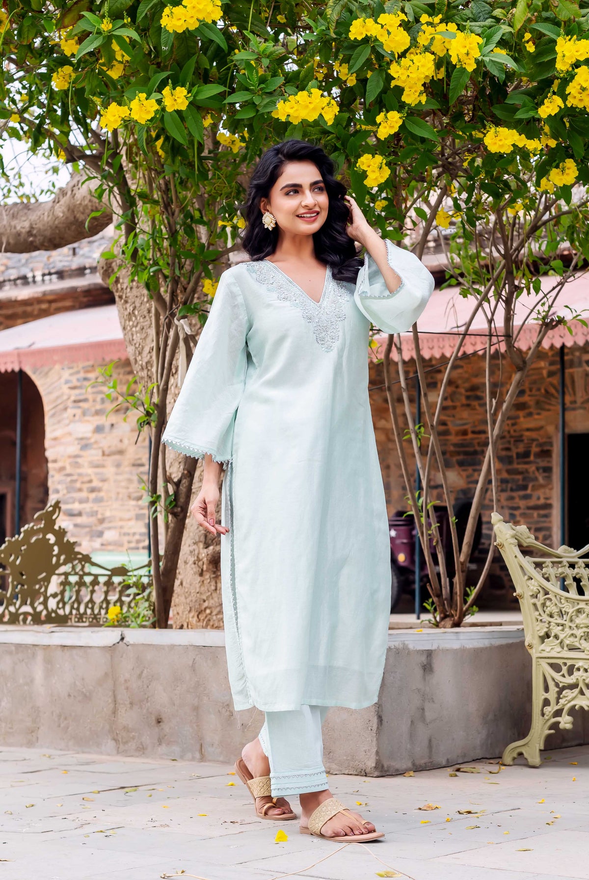 Woman wears a pale mint chanderi silk kurta set with embroidered neckline and lace trim.