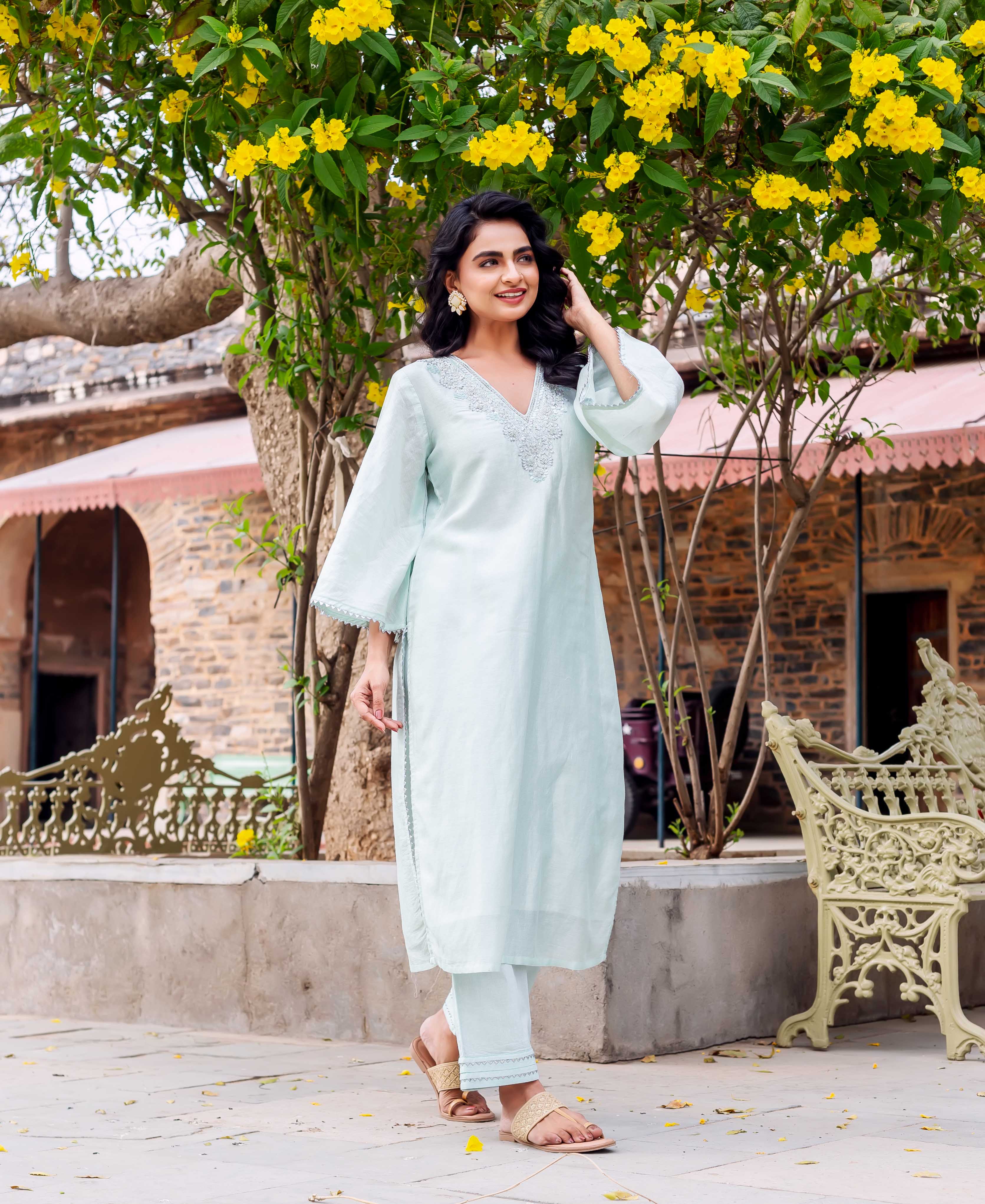 Woman wears a pale mint chanderi silk kurta set with embroidered neckline and lace trim.