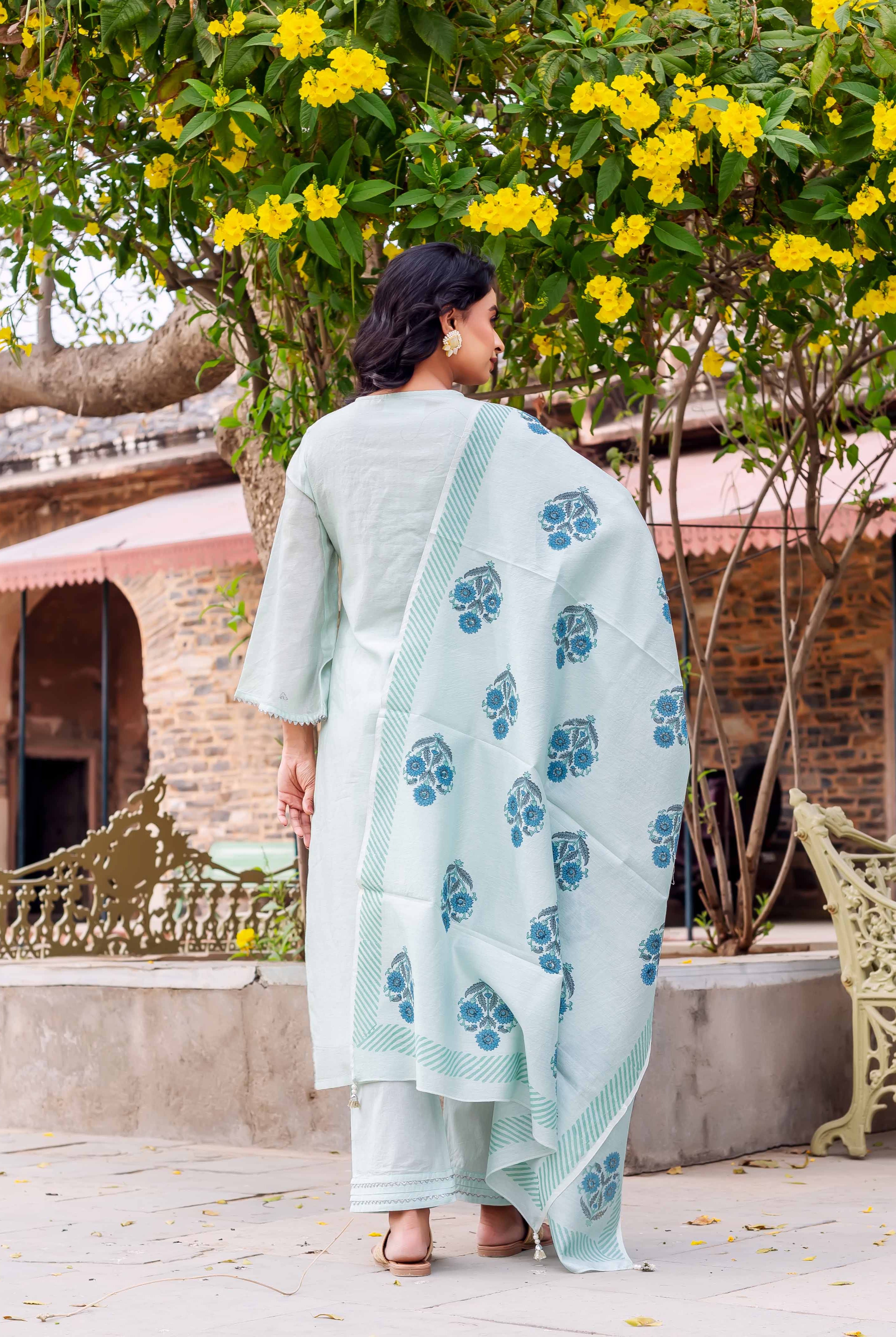 Woman from behind in mint green kurta set, blue floral block print dupatta with striped borders.